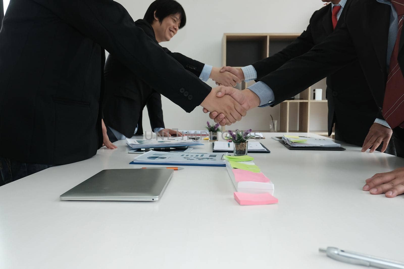 Business people shaking hands after finishing up meeting. Two colleagues handshaking after conference. Greeting deal, teamwork, partnership, corporate concept. by pp99
