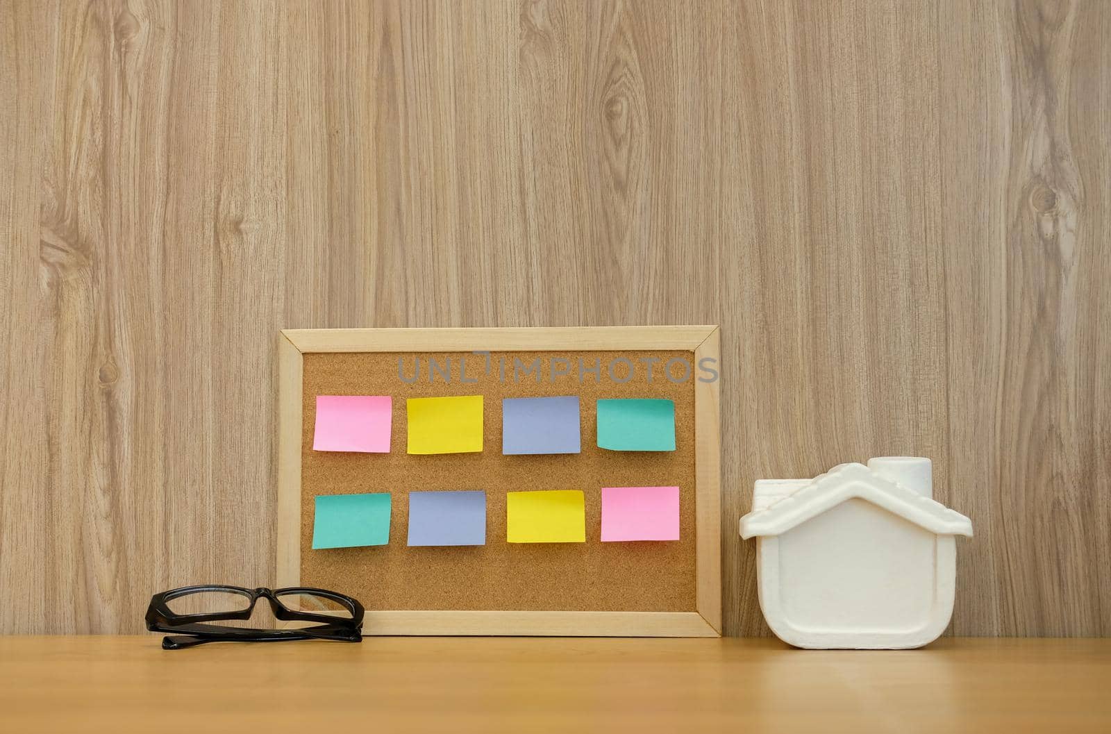 sticky notes paper reminder on cork board & house model on wooden desk. real estate investment. property buying mortgage loan