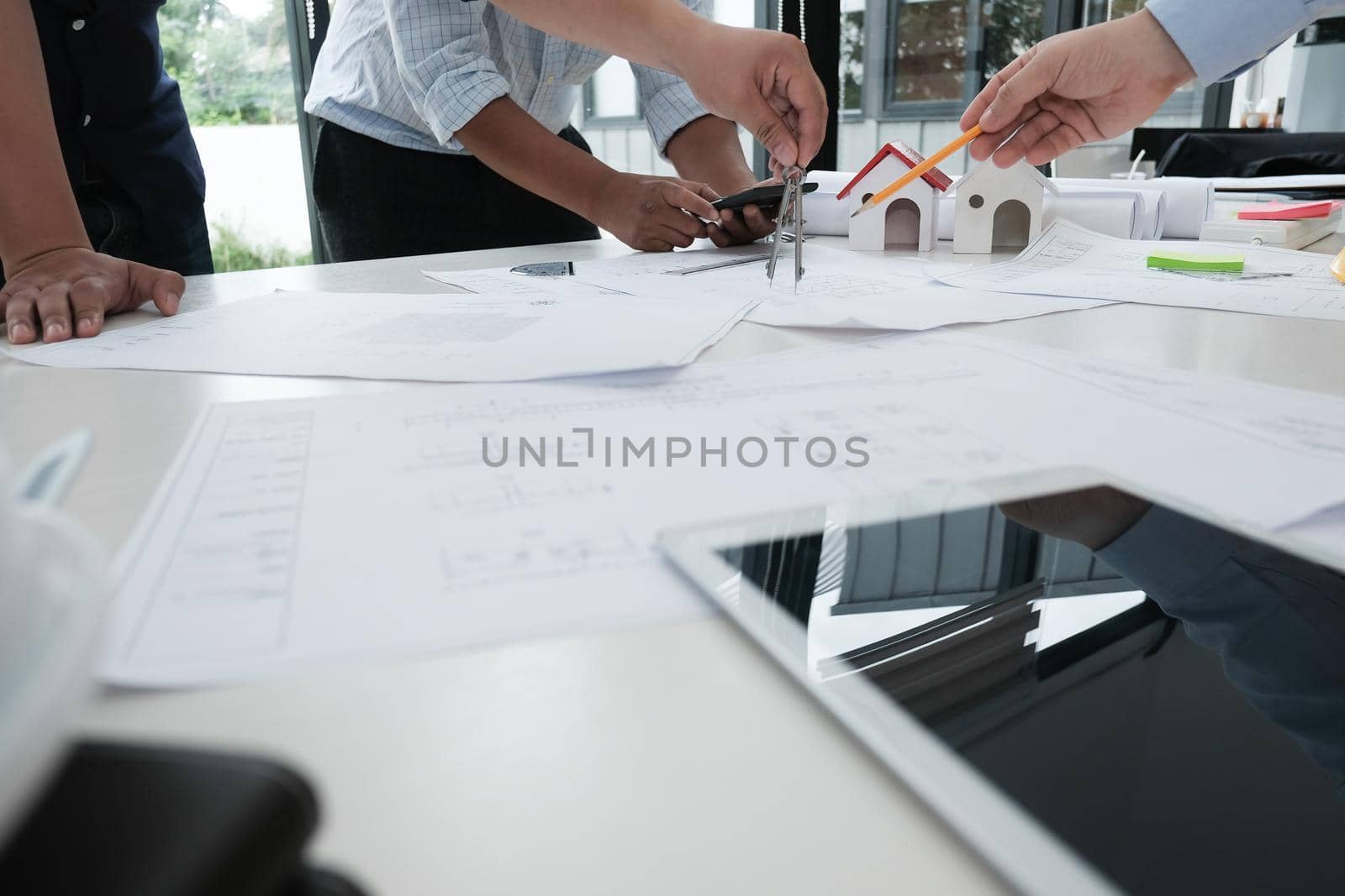 architect working on real estate project with partner at workplace. engineer discussing with colleague on living house blueprint at office. construction & building concept