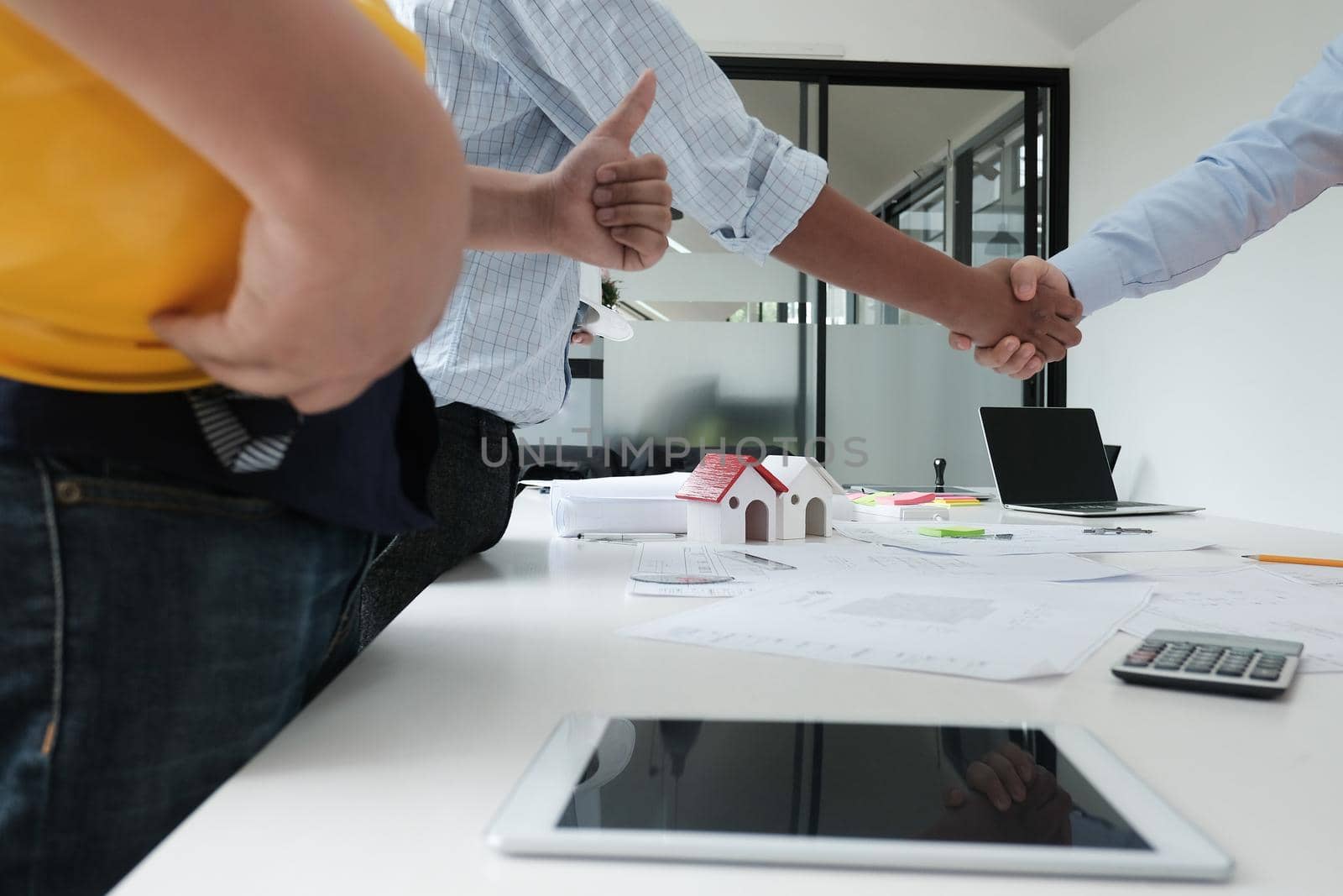 architect & customer shaking hands at workplace. Engineer handshaking with partner for successful deal in building project development. business teamwork concept