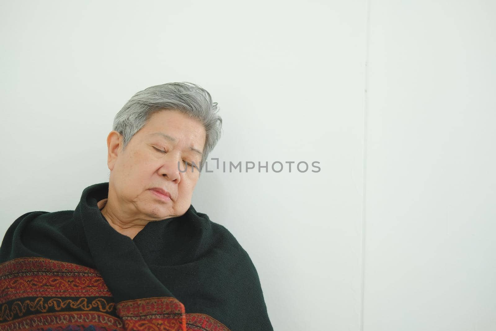 elder woman taking a nap. asian elderly female senior napping sleeping near white wall