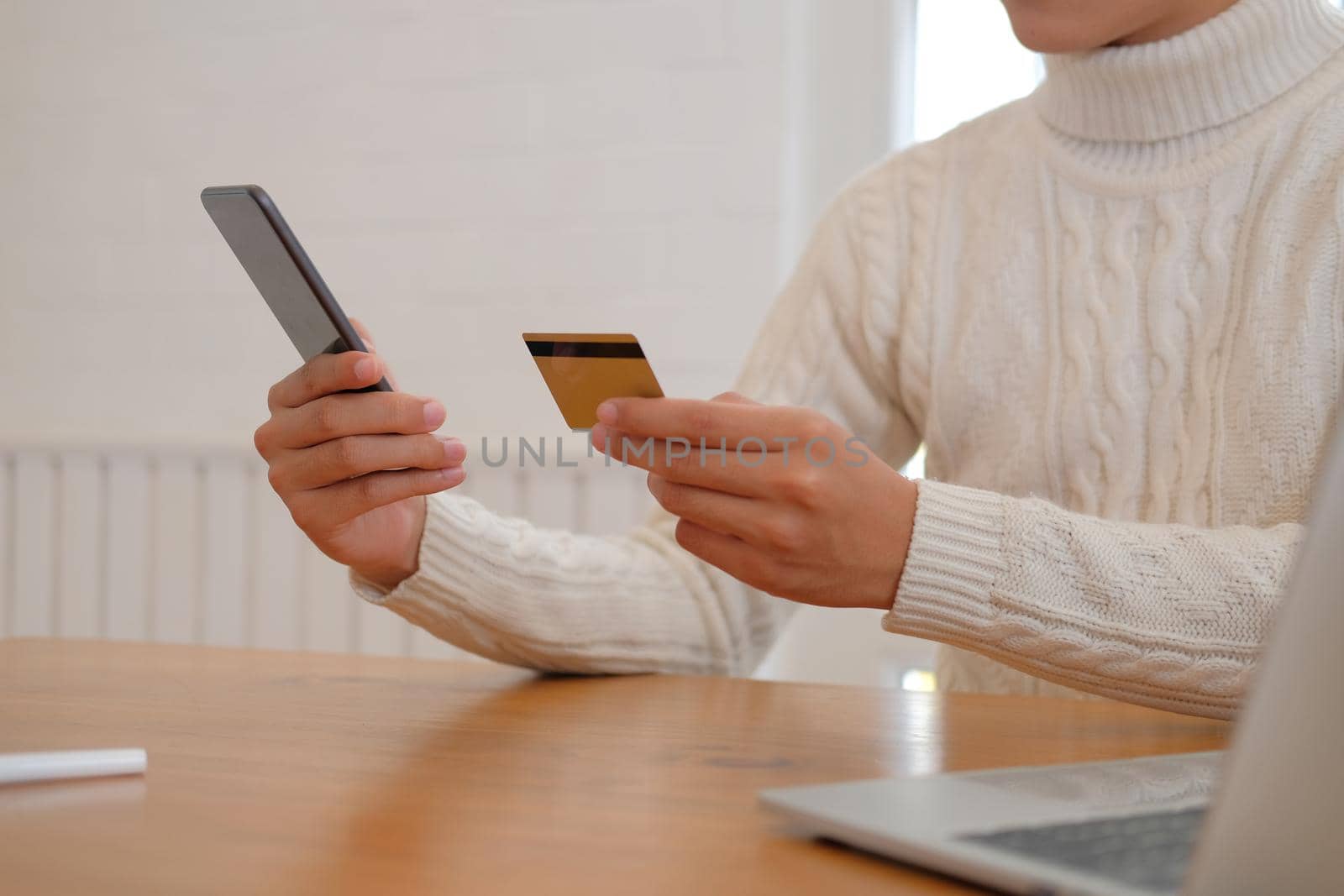 man holding credit card & smart phone for online shopping.  male buyer buying or make payment on internet.