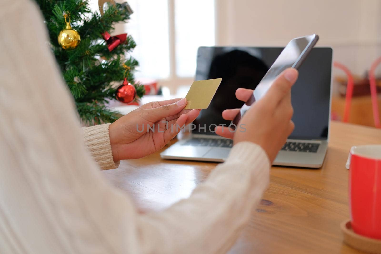 man holding credit card & smart phone for online shopping.  male buyer buying christmas gift on internet. xmas new year holiday celebration by pp99