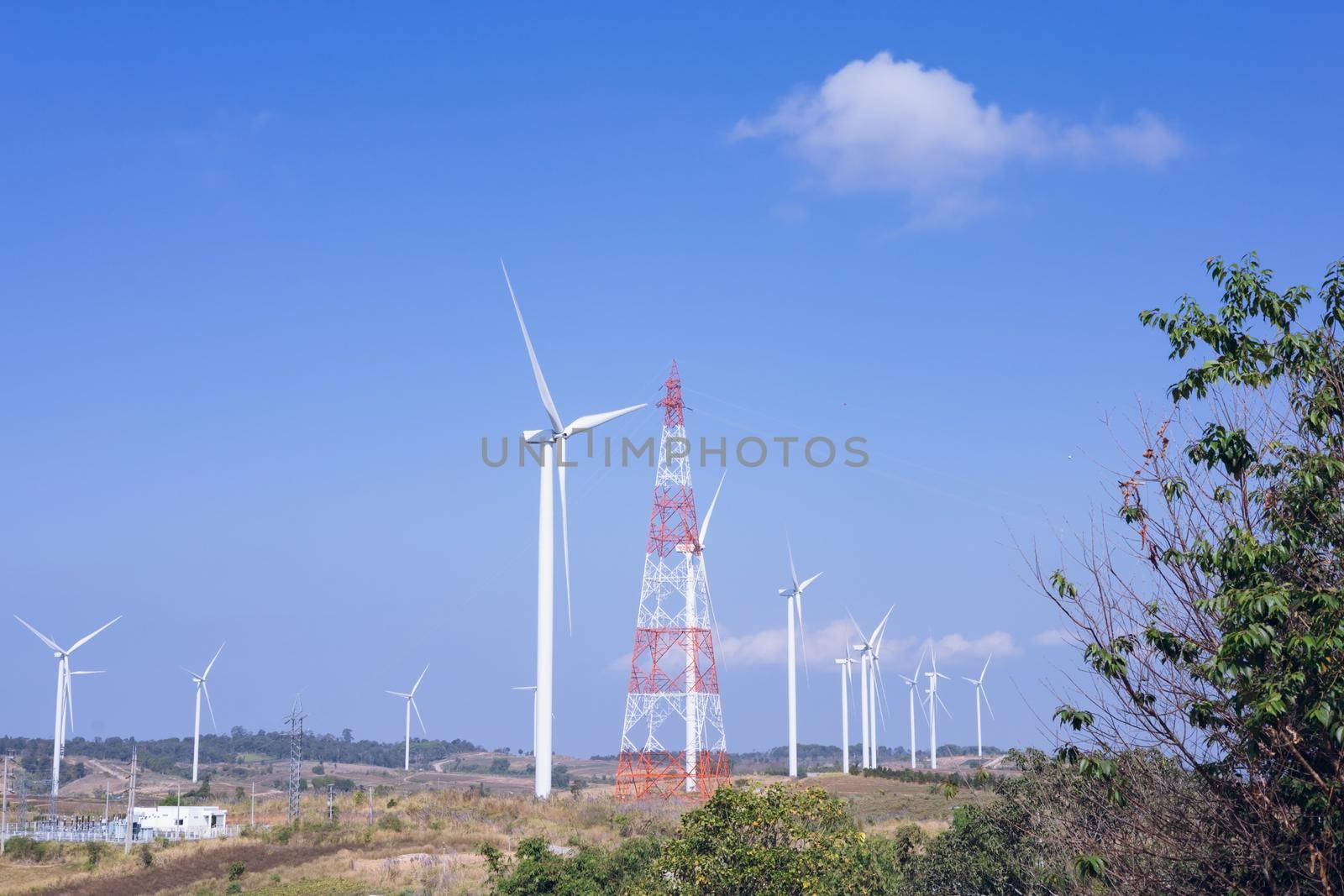 Offshore wind power and energy farm with many wind turbines on the mountain by iPixel_Studio