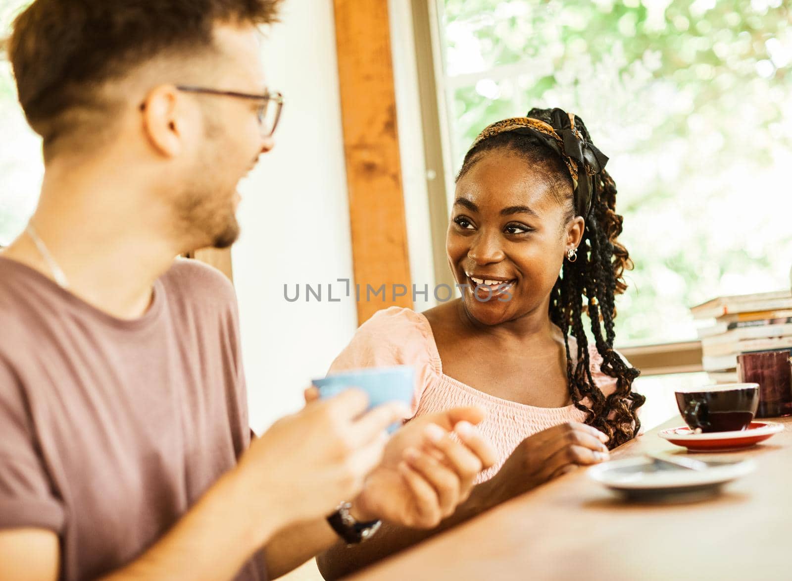 Happy young couple smiling and talking in a coffee shop cafe