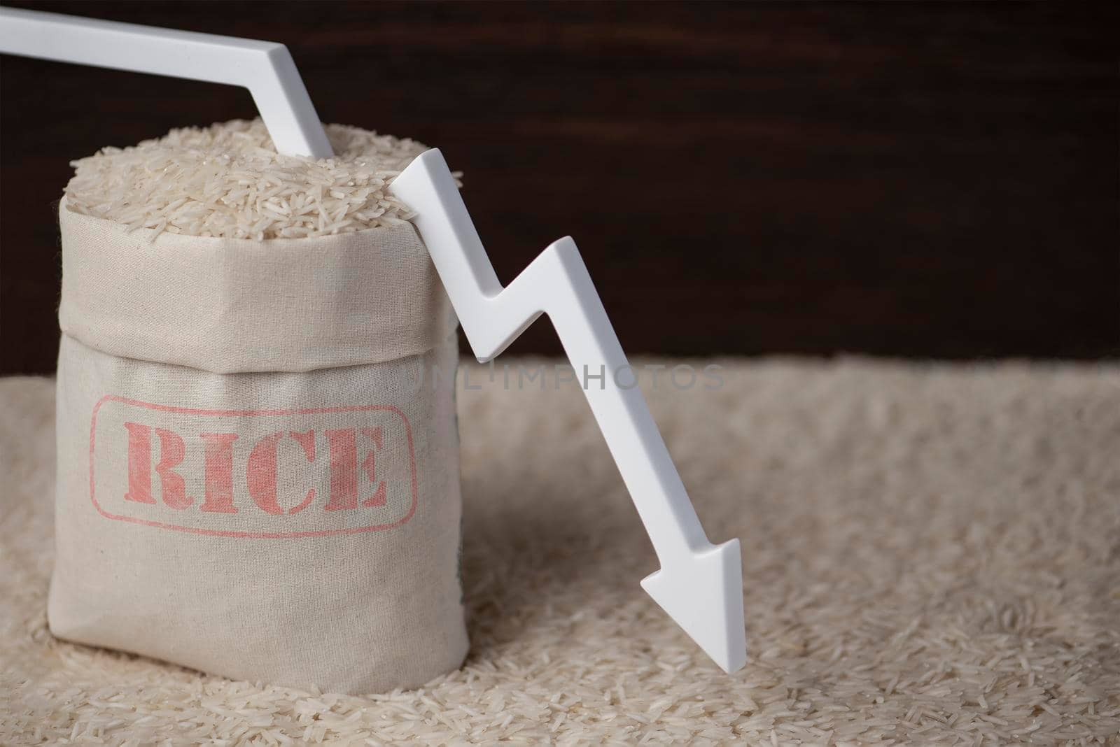 Rice harvest. Poor agricultural crops, food shortages, world hunger. A bag of rice on a brown background with a white arrow pointing down. by SERSOL