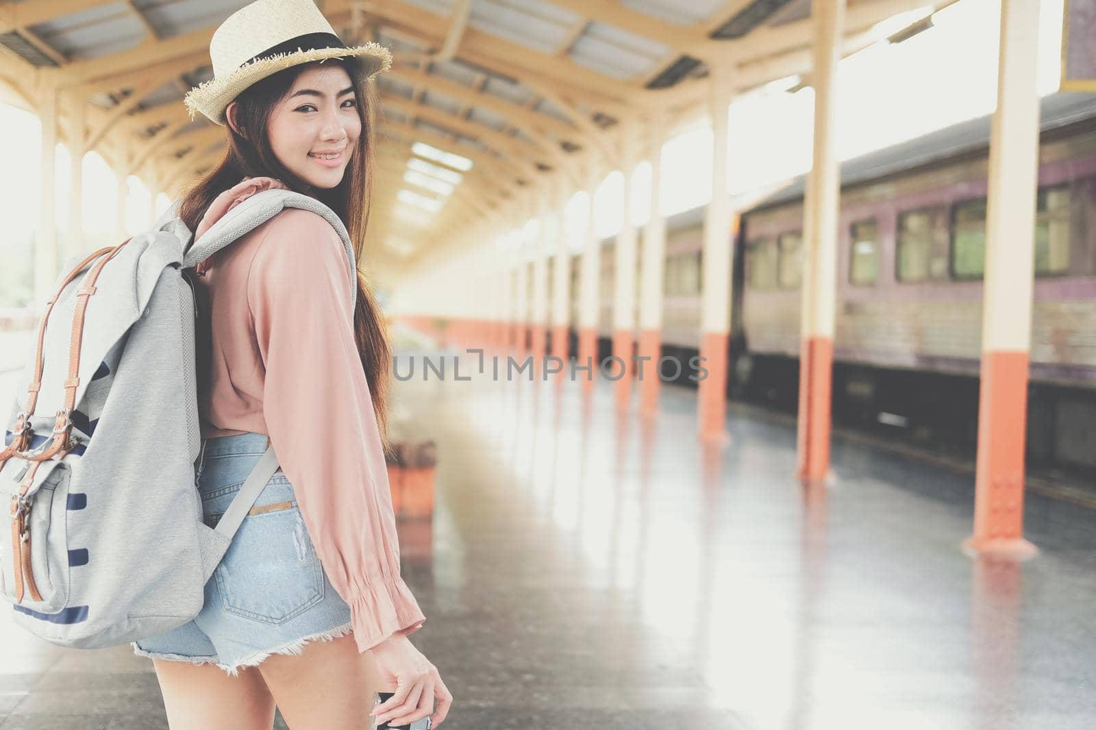 young asian woman  backpacker traveler with camera backpack at train station. journey trip travel concept