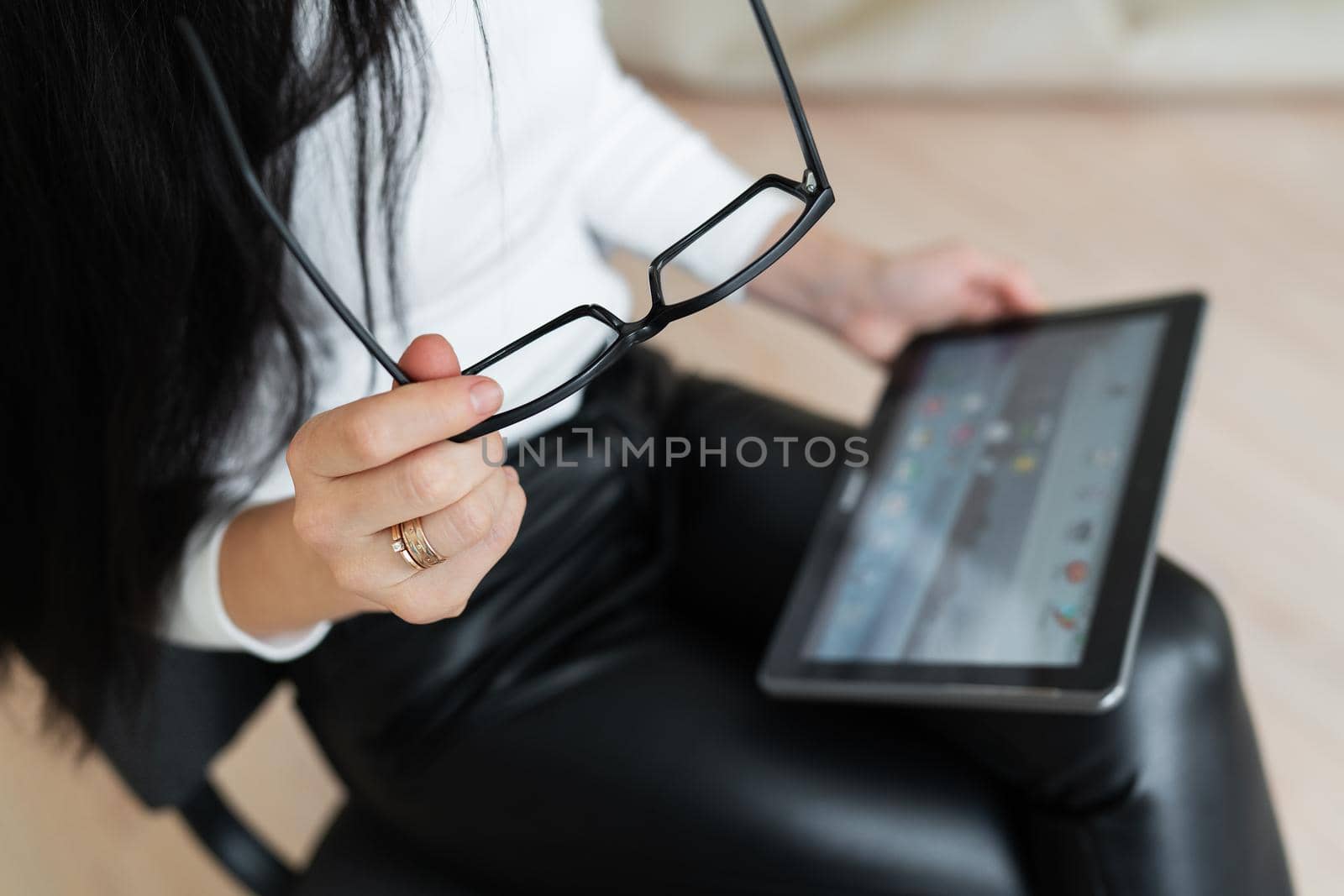 A young business girl solves problems online on a tablet. Young woman chatting on a virtual online conference. The concept of communication is not in the office, online work