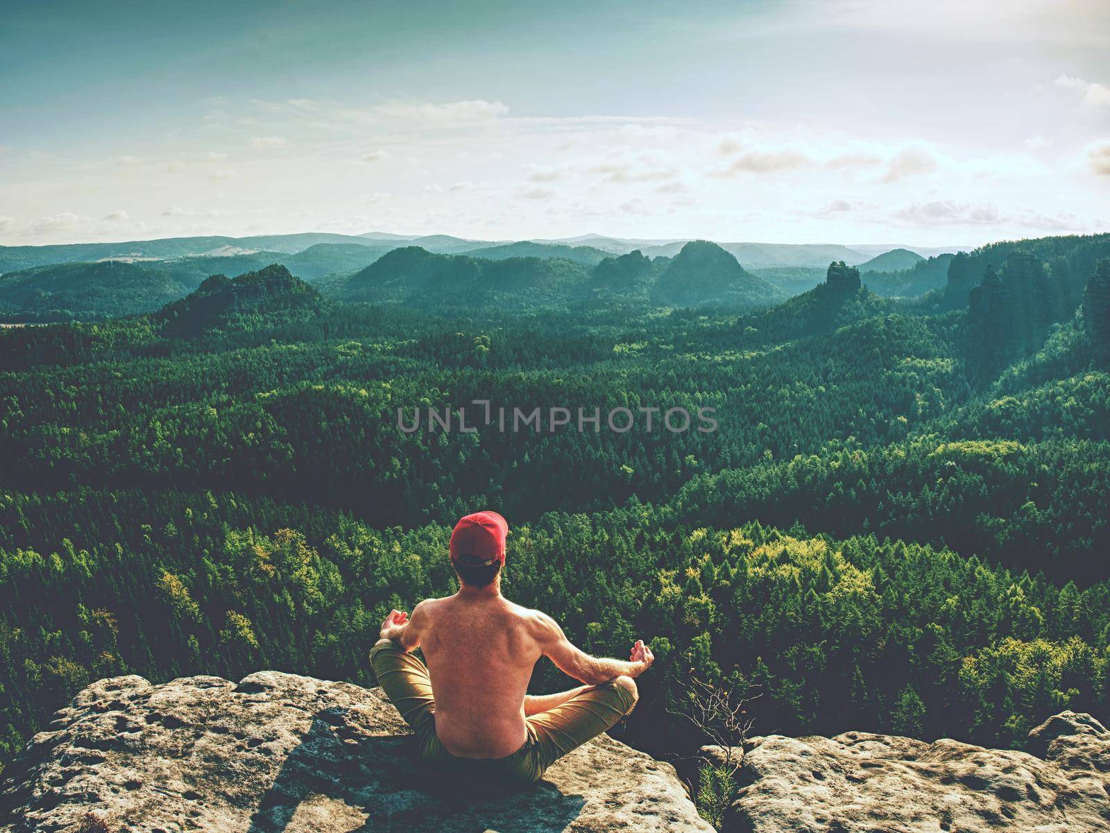 Naked man in yoga lotus pose for breathing, meditating and relaxing. Sportsman doing an Yoga Exercise Sitting against 