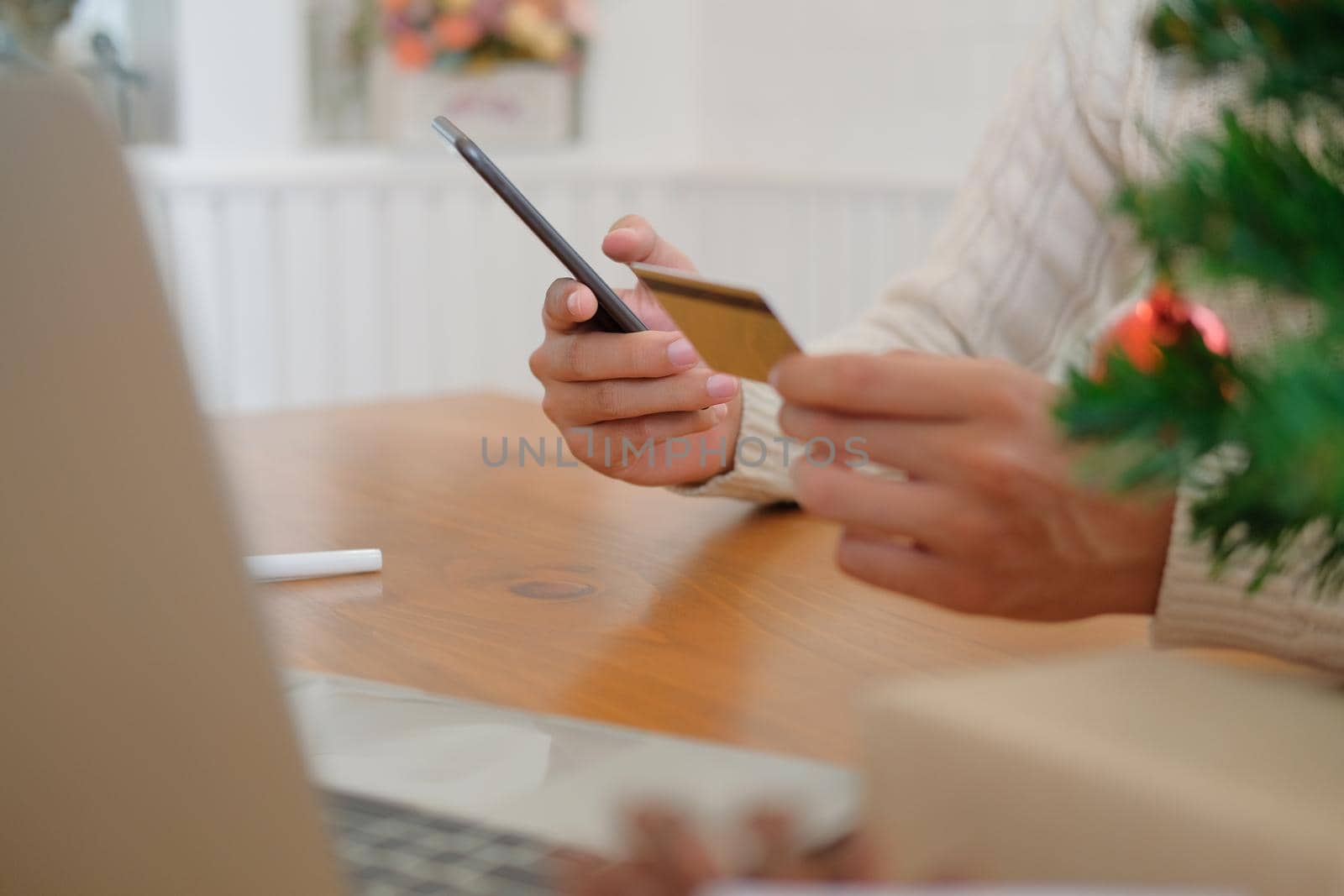 man holding credit card & smart phone for online shopping.  male buyer buying christmas gift on internet. merry xmas new year holiday celebration