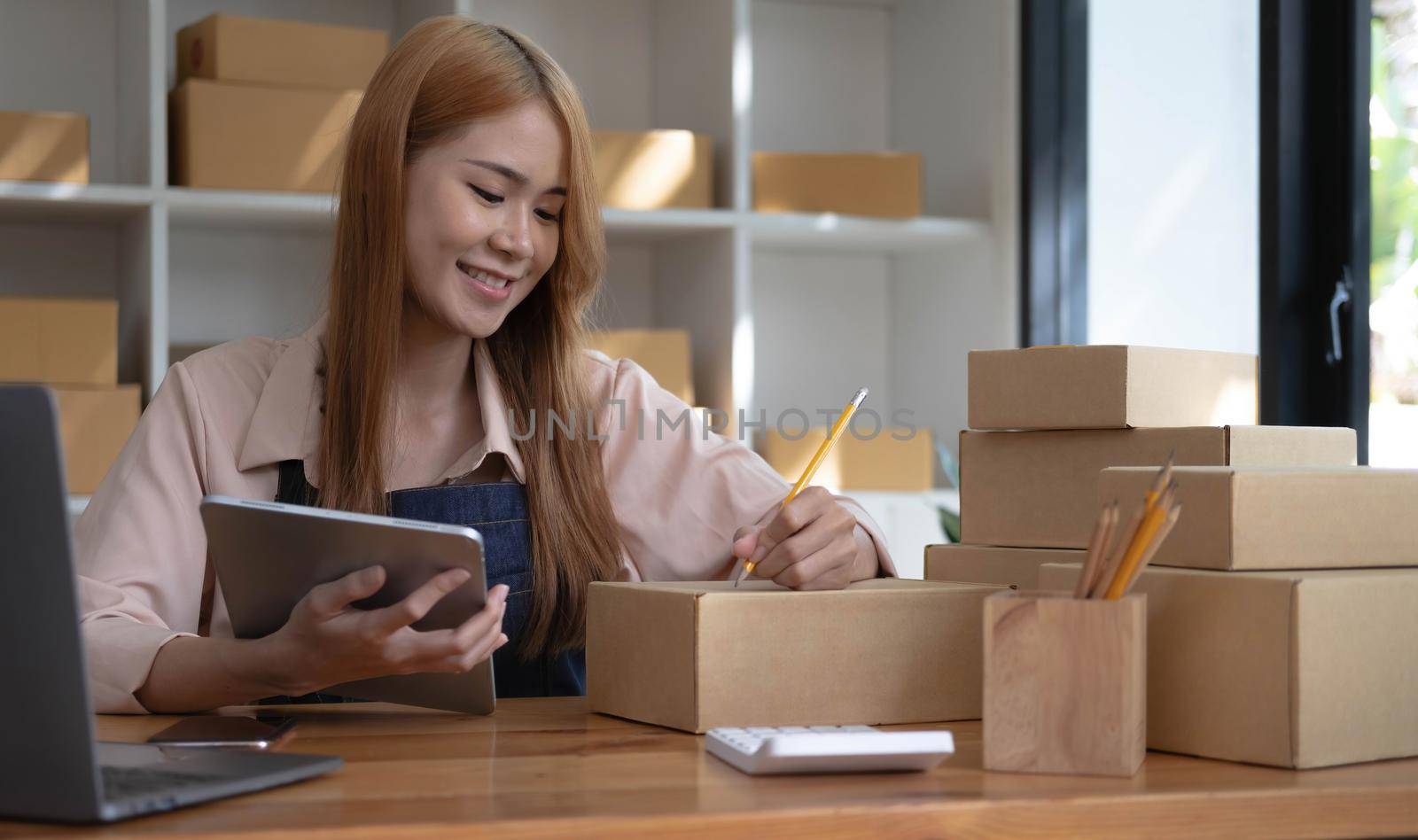 Startup successful small business owner sme beauty girl stand with tablet smartphone in coffee shop restaurant. Portrait of asian tan woman barista cafe owner. SME entrepreneur seller business concept.