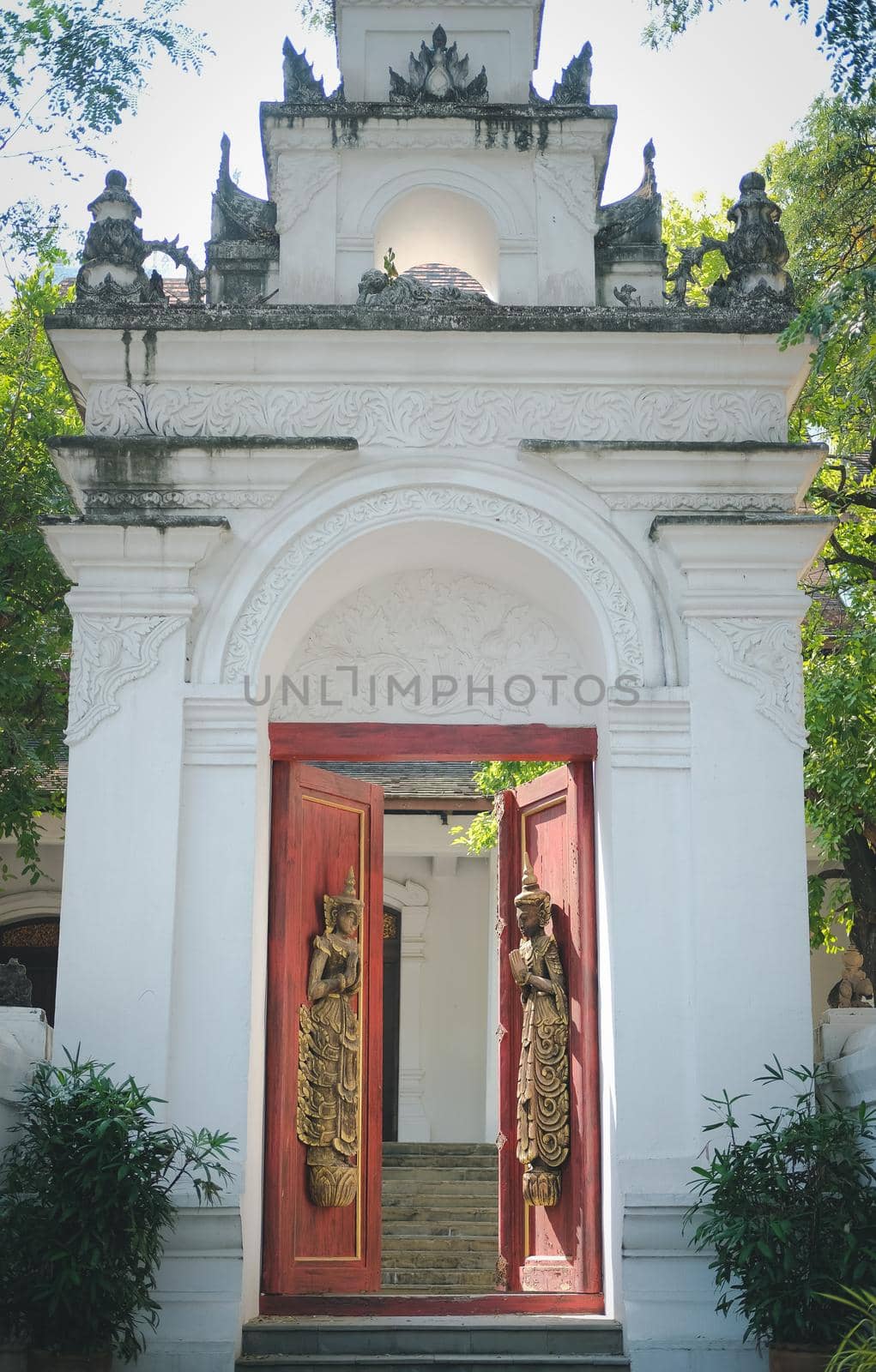 old vintage wooden door arch with asian angel sculpture