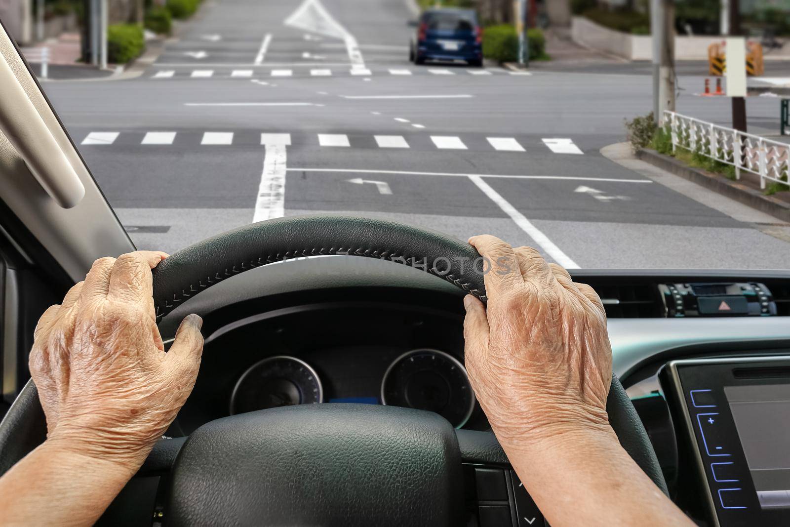 Senior woman driving a car on street in city. by toa55