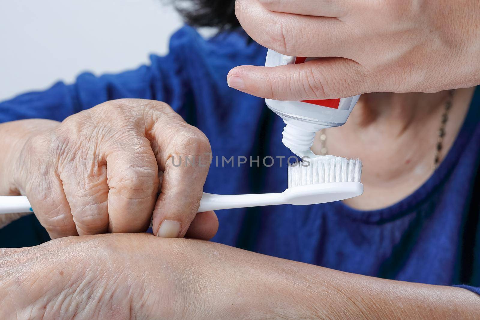 Asian elderly woman trying use toothbrush ,hand tremor . Dental health by toa55
