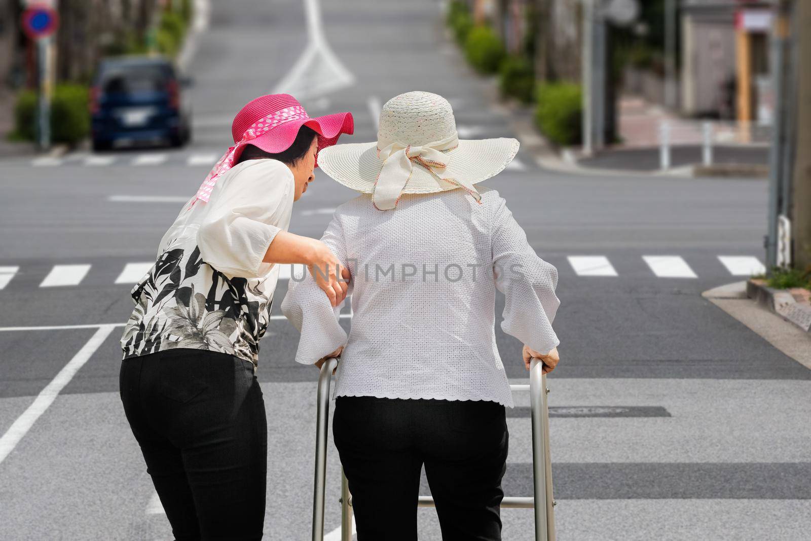 Daughter take care elderly woman walking on street in  downtown.