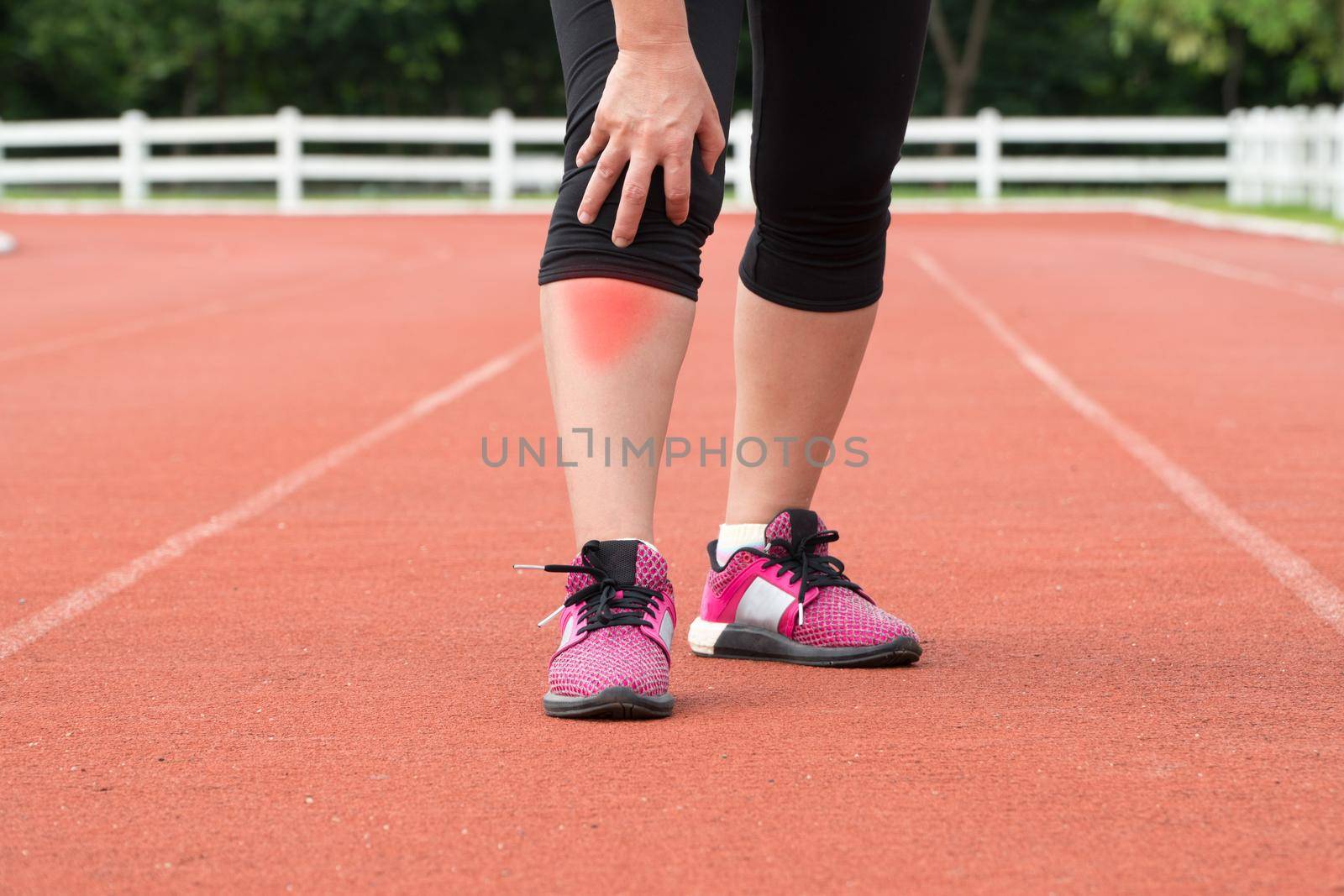 Middle aged woman runner knee pain during training outdoors. by toa55