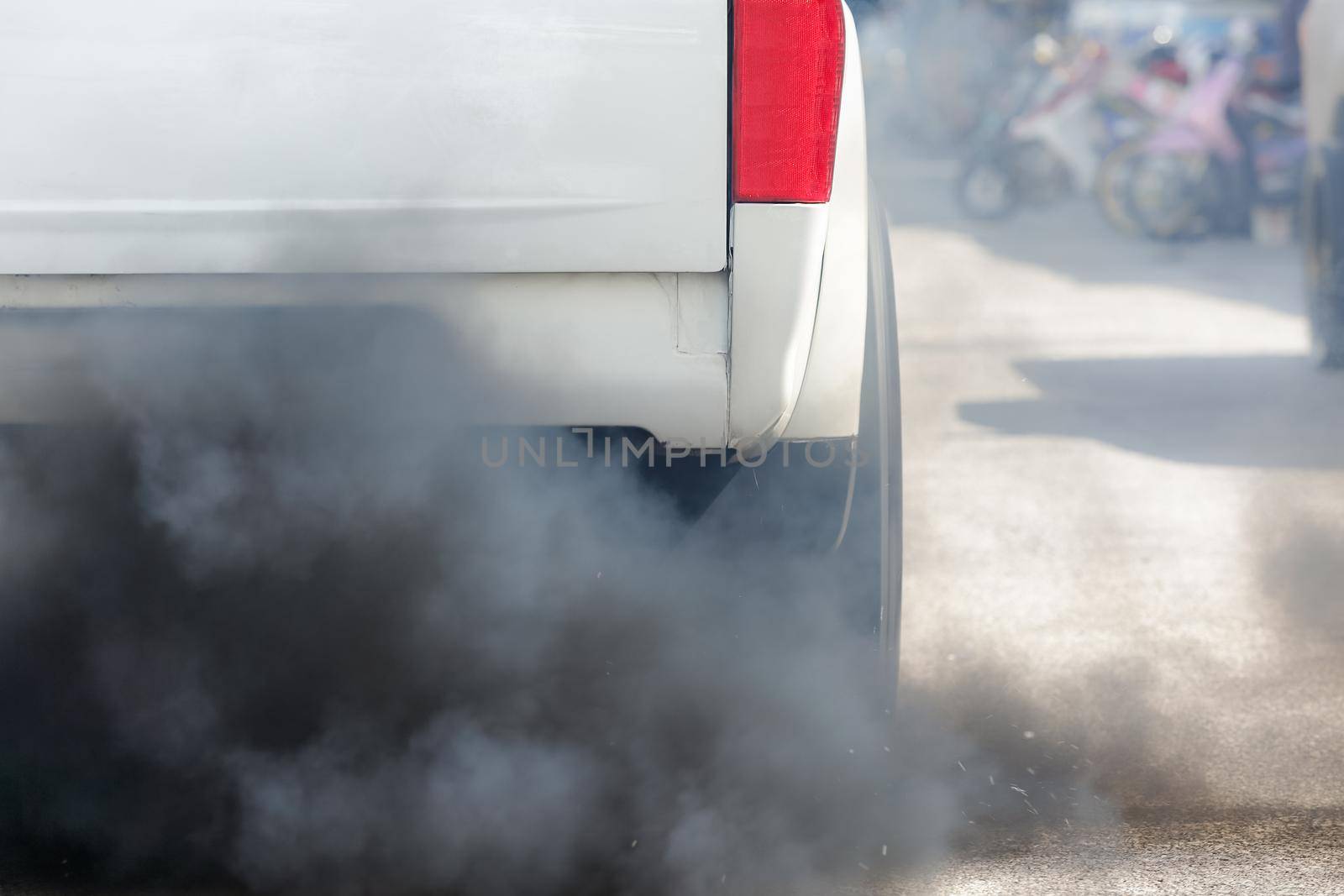 Air pollution from vehicle exhaust pipe on road
