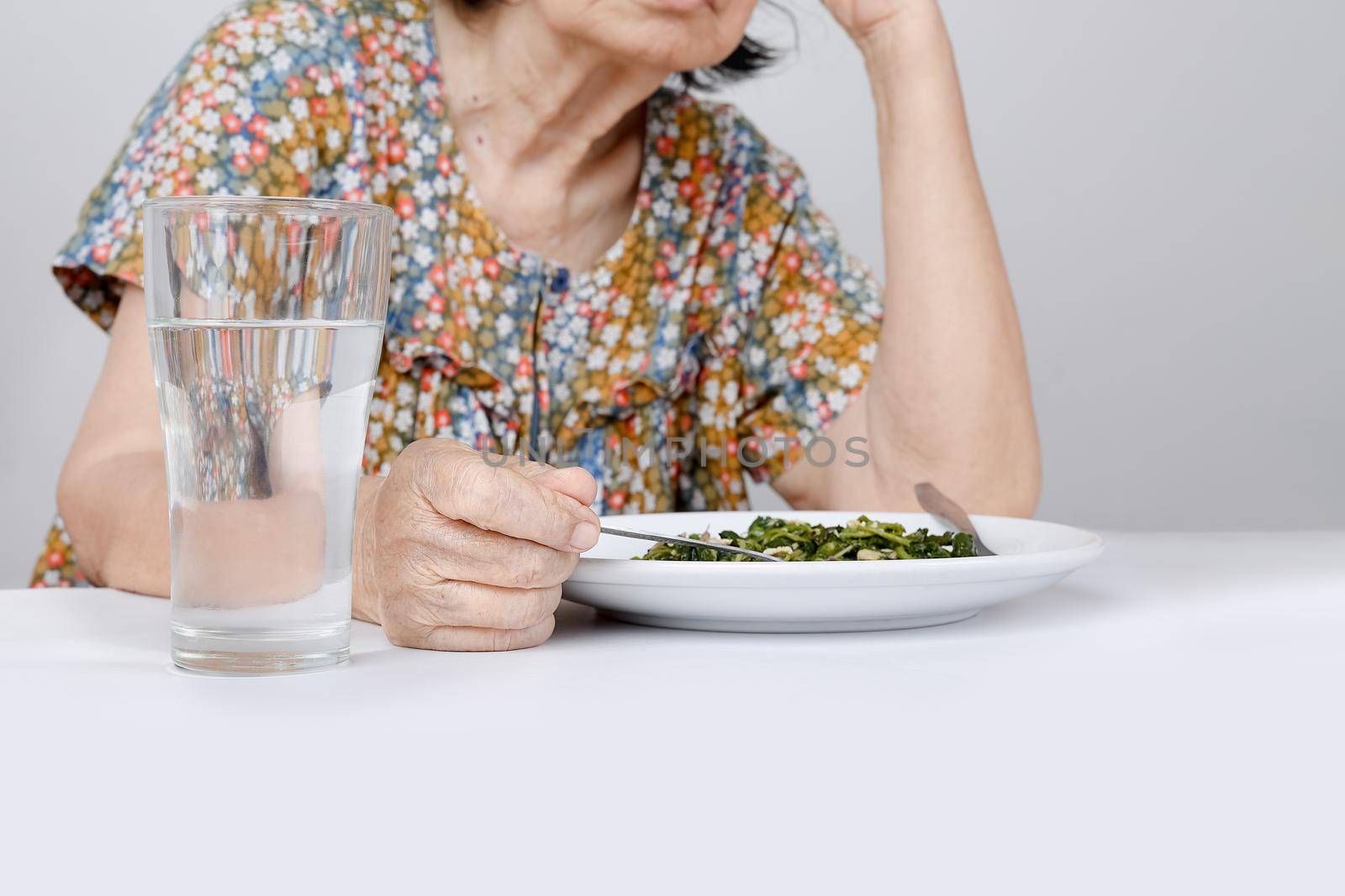 Elderly asian woman bored with food