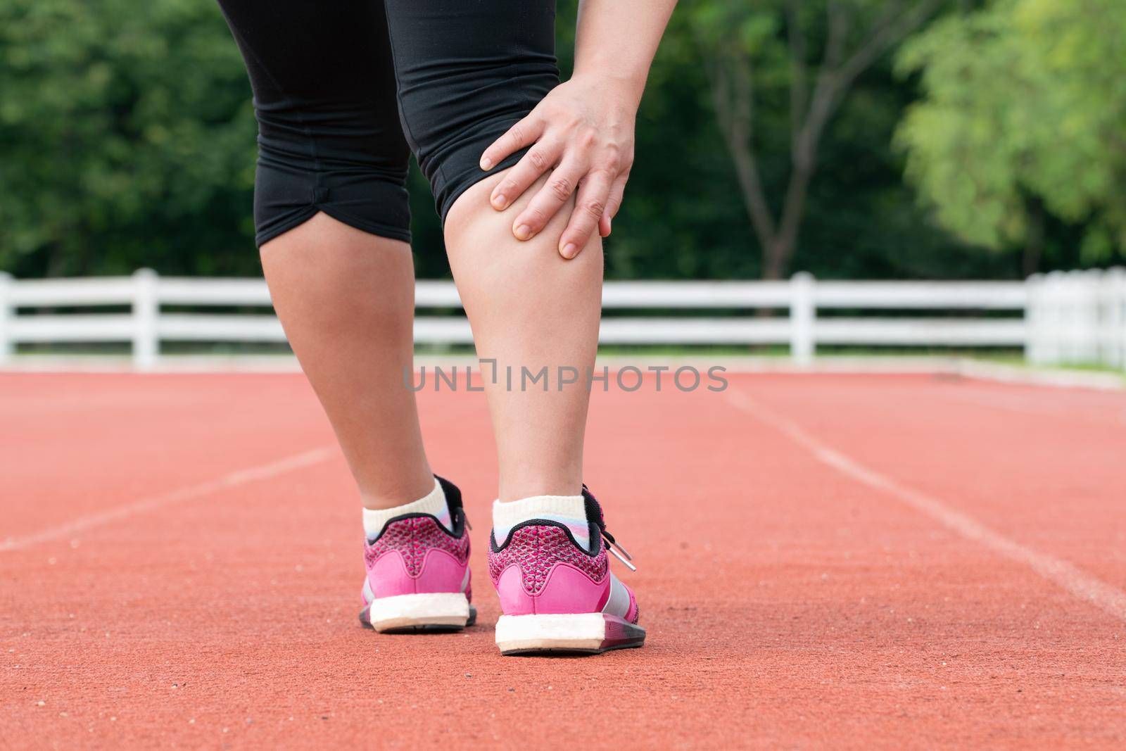 Middle aged woman runner muscle pain during training outdoors by toa55