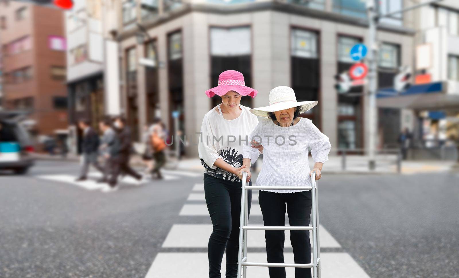 Daughter take care elderly woman walking across the street in downtown by toa55