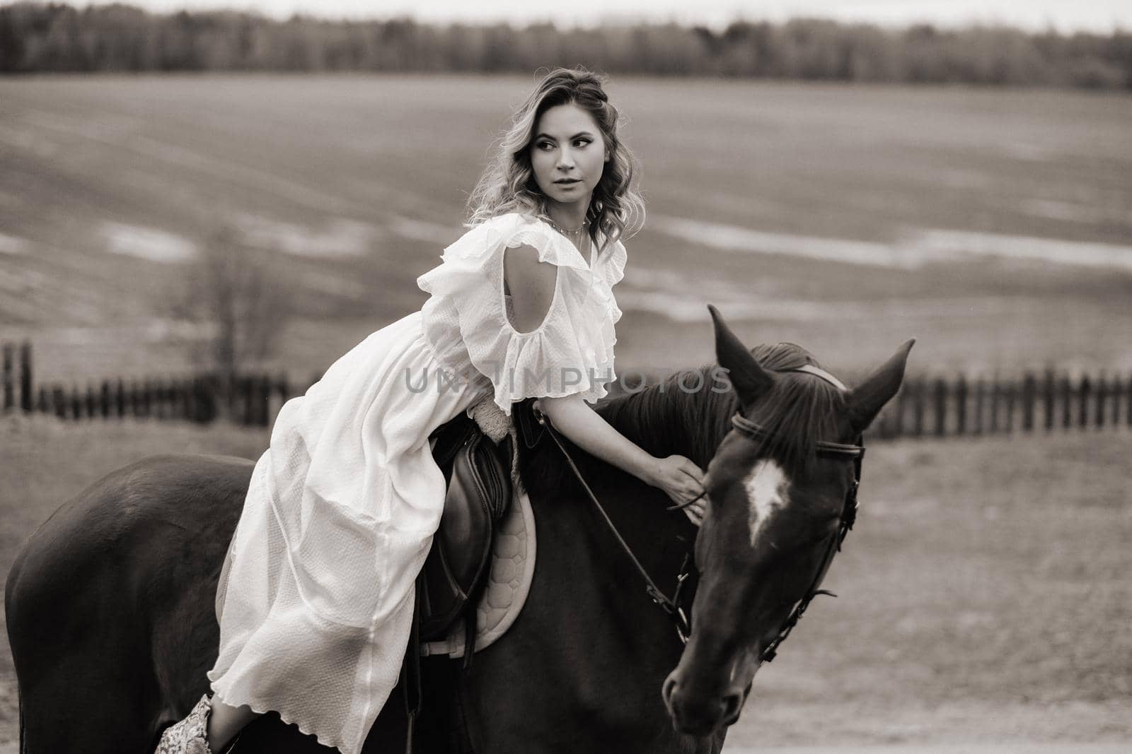 A woman in a white sundress riding a horse in a field. black and white photo by Lobachad