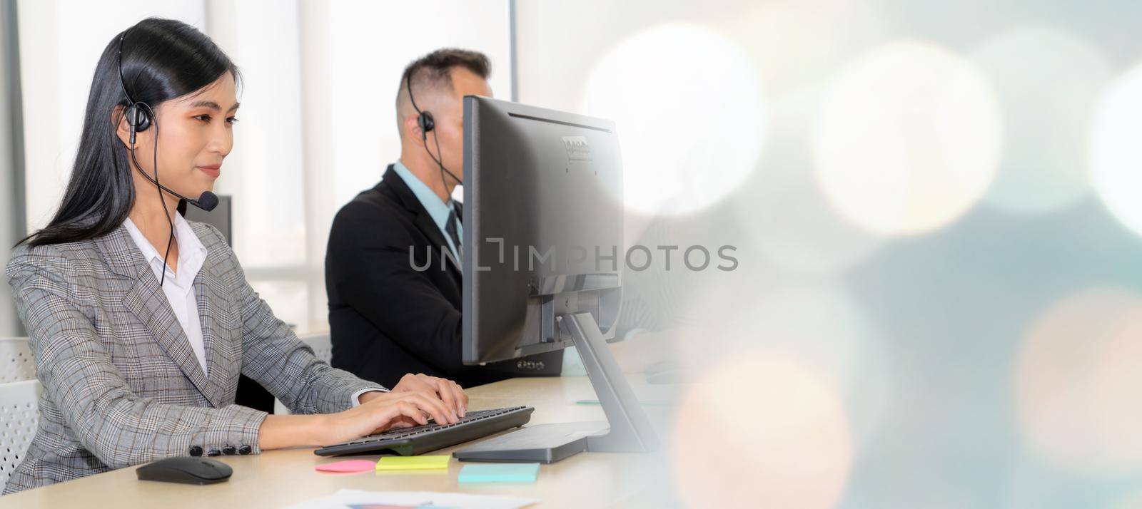 Business people wearing headset working in office to support remote customer or colleague. Call center, telemarketing, customer support agent provide service in broaden view .