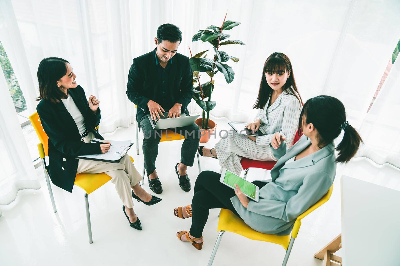 Business people proficiently discuss work project while sitting in circle . Corporate business team collaboration concept .