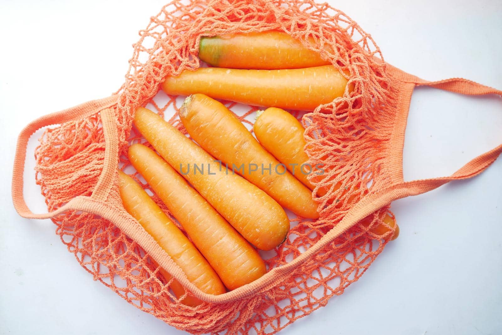 fresh carrots in shopping bag on white ,