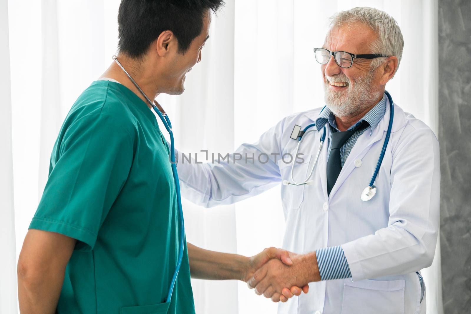 Senior male doctor working with another doctor in hospital. Concept of medical healthcare and doctor staff education.