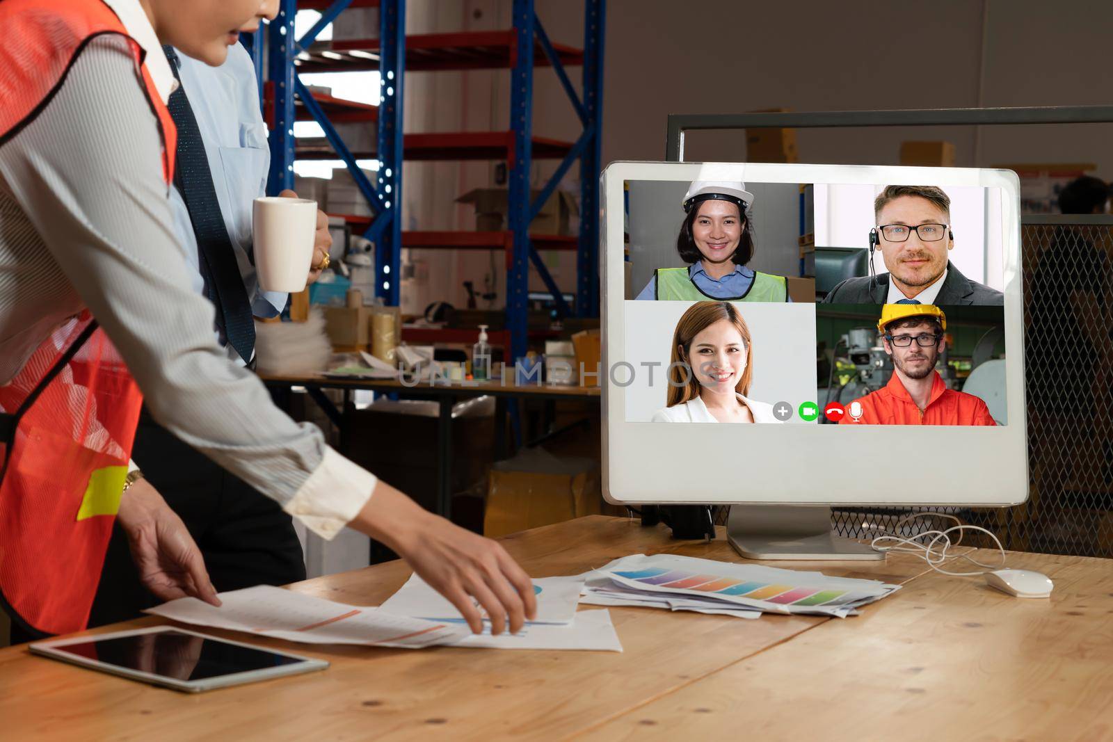 Warehouse staff talking on video call at computer screen in storage warehouse . Online software technology connects people working in logistic factory by virtual conference call on internet network .