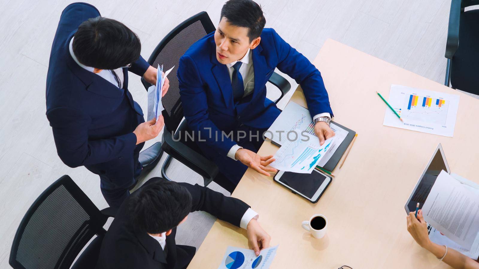 Business people group meeting shot from top view in office . Profession businesswomen, businessmen and office workers working in team conference with project planning document on meeting table .