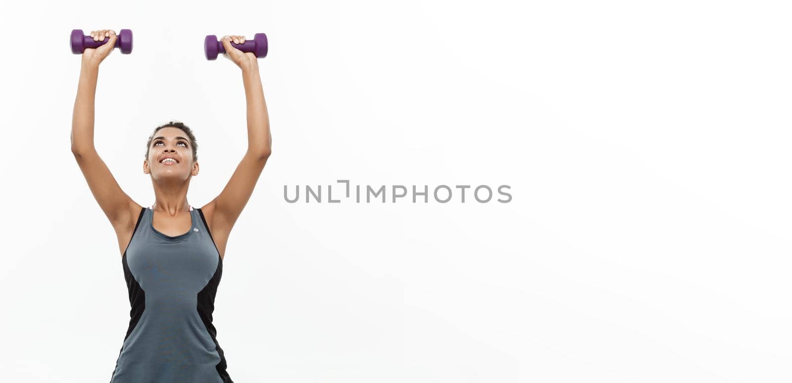 Healthy and Fitness concept - Beautiful American African lady in fitness clothes workout with dumbbell. Isolated on white background. by Benzoix
