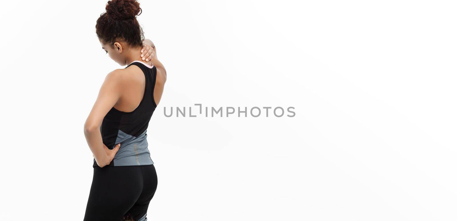 Healthy and Fitness concept - portrait of African American girl suffers a muscle injury standing holding her neck and lower back with back view. Isolated on white background