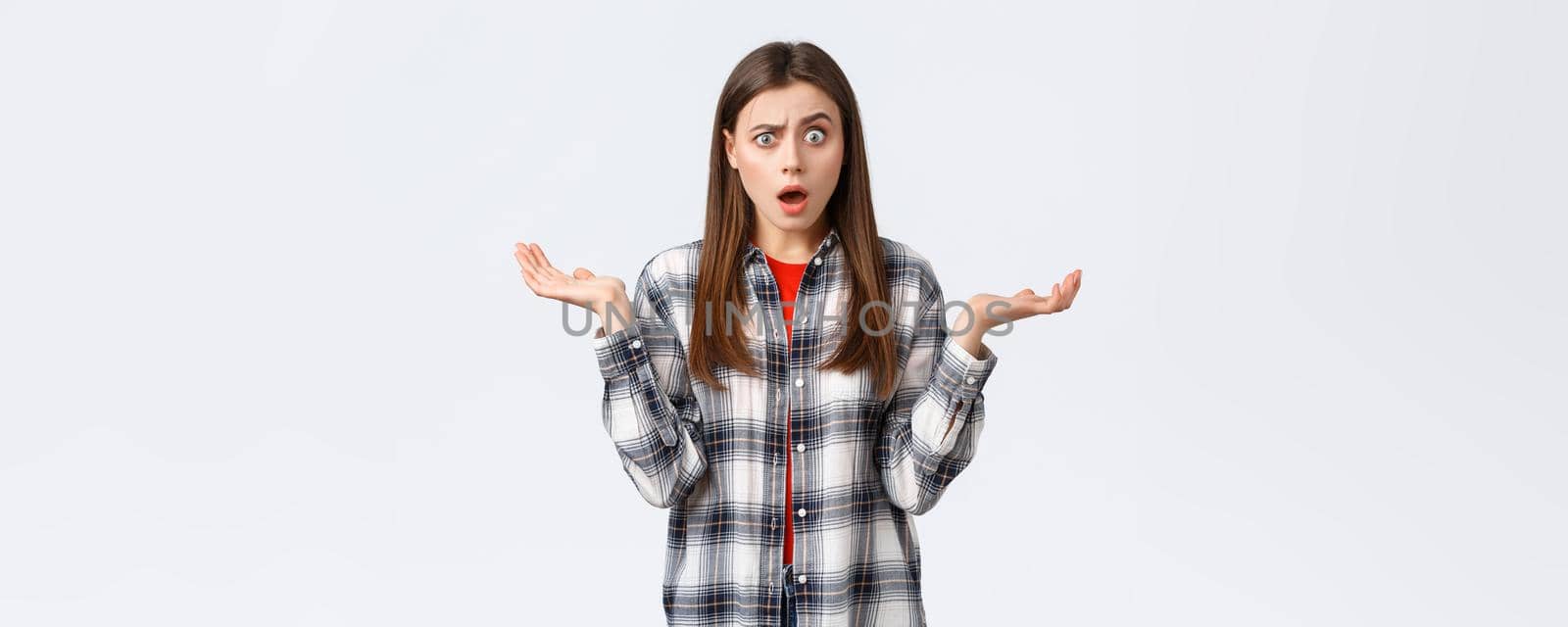 Lifestyle, different emotions, leisure activities concept. Confused and surprised young woman gasping, drop jaw and stare startled from big news, spread hands sideways, unexpected situation.