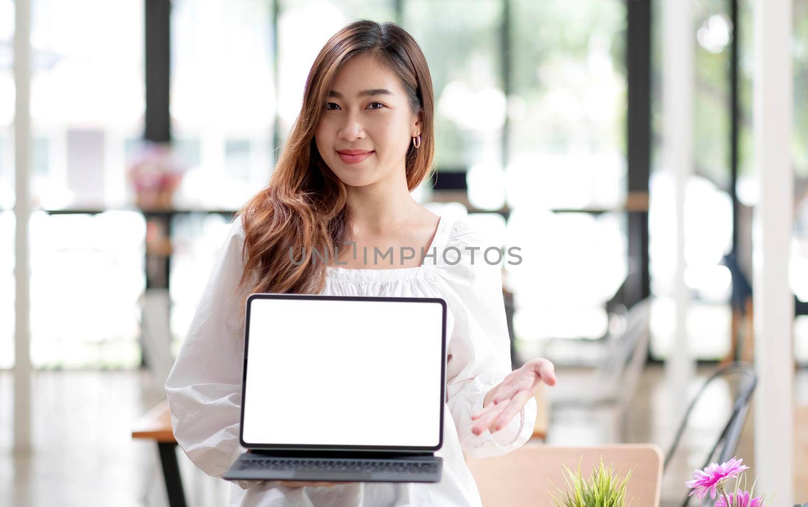 Happy young asian woman clothes on white background. People lifestyle concept. Mock up copy space. Hold laptop pc computer with blank empty screen.