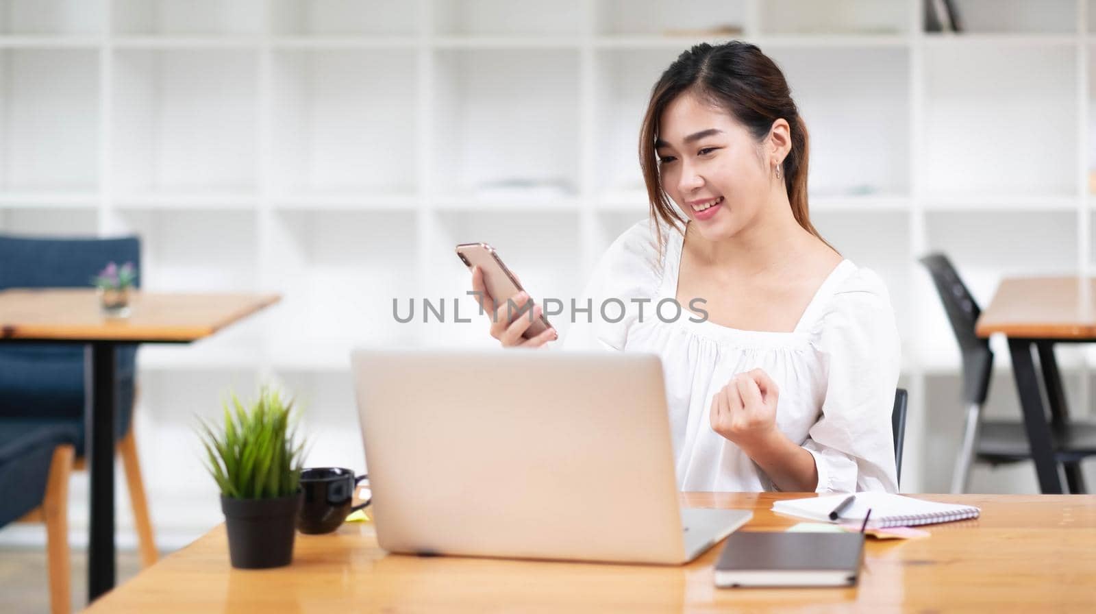 Young asian businesswoman beautiful charming smiling and using on mobile phone in the office..