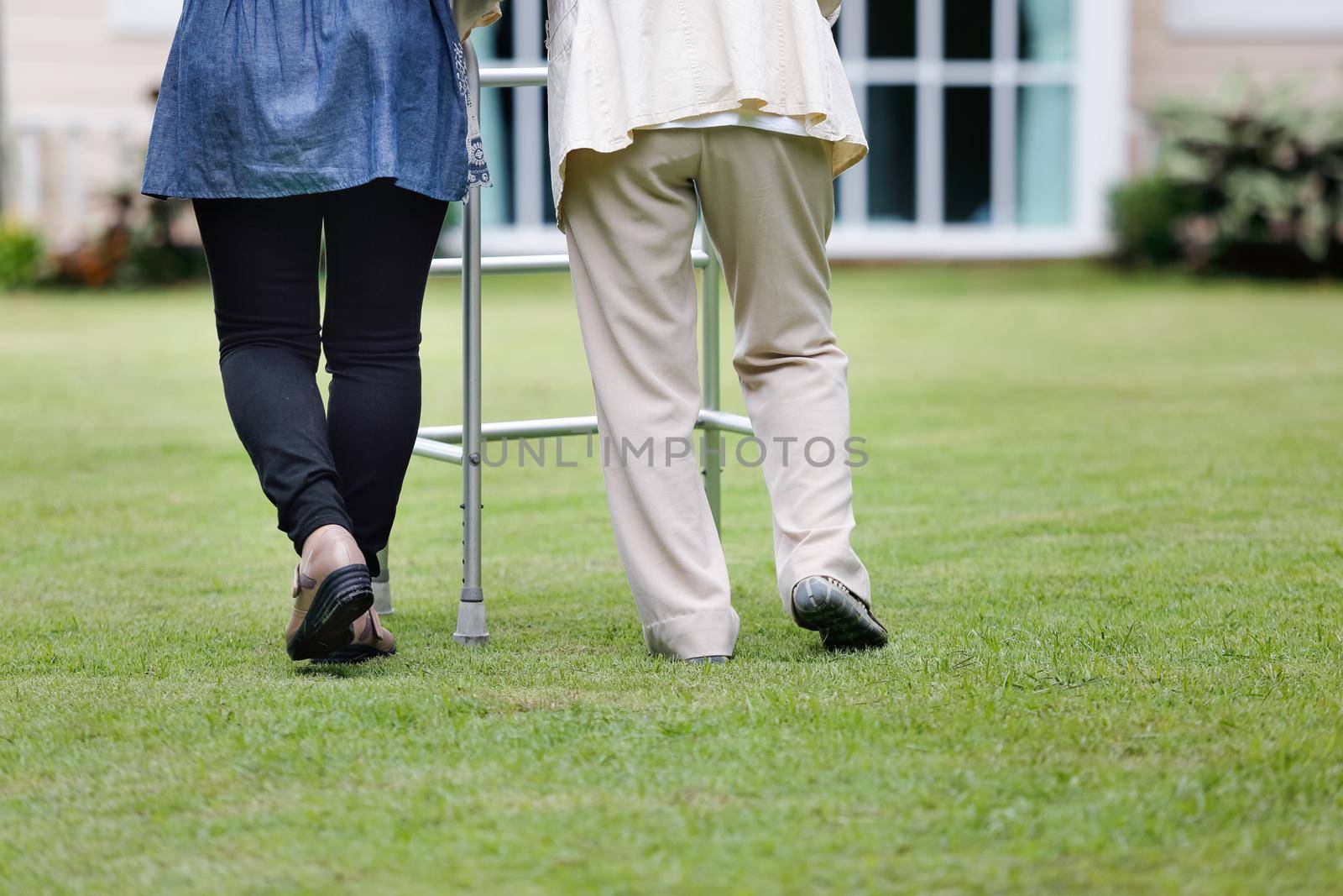 Elderly woman exercise walking in backyard with daughter