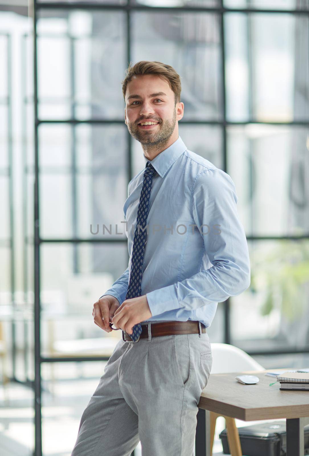 Young businessman working at modern glass office by Prosto
