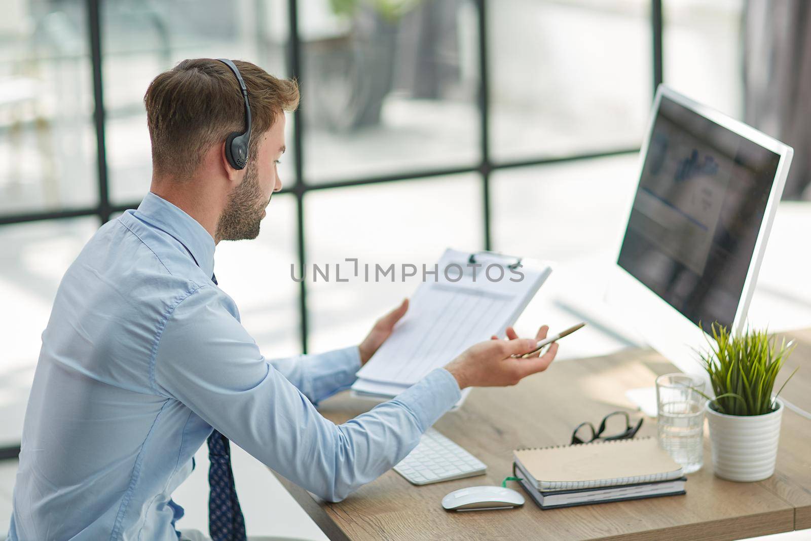 Man with headphones and laptop working in office by Prosto