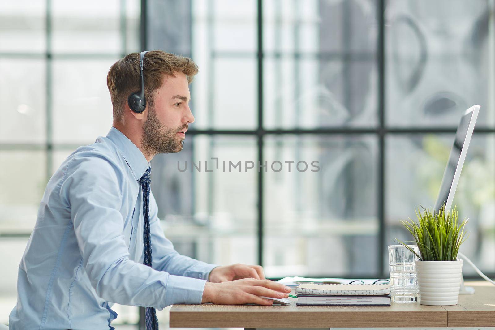 Man with headphones and laptop working in office by Prosto