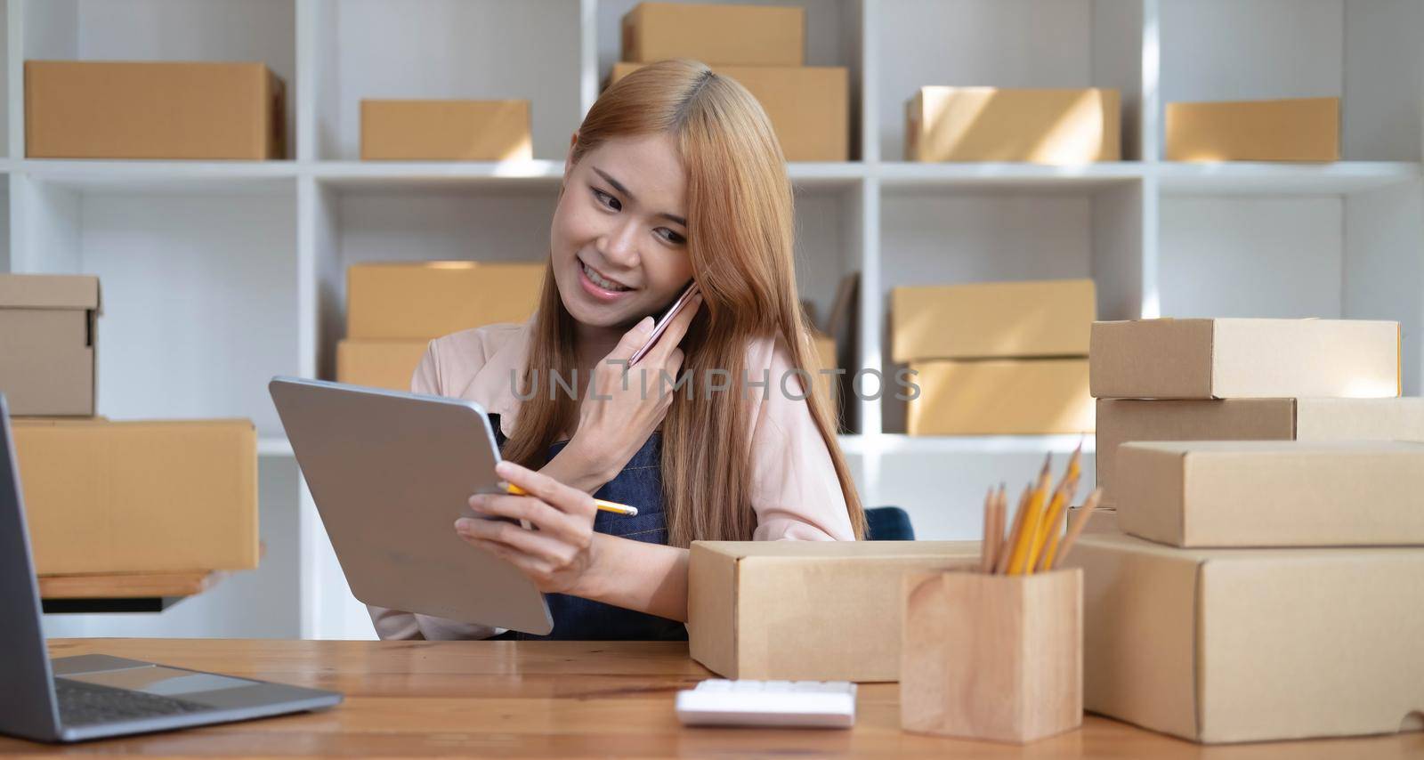 Small start-up business owners using computers and phones at work, salespeople, checking production orders. Pack products to ship to customers, sell ecommerce shipping ideas..