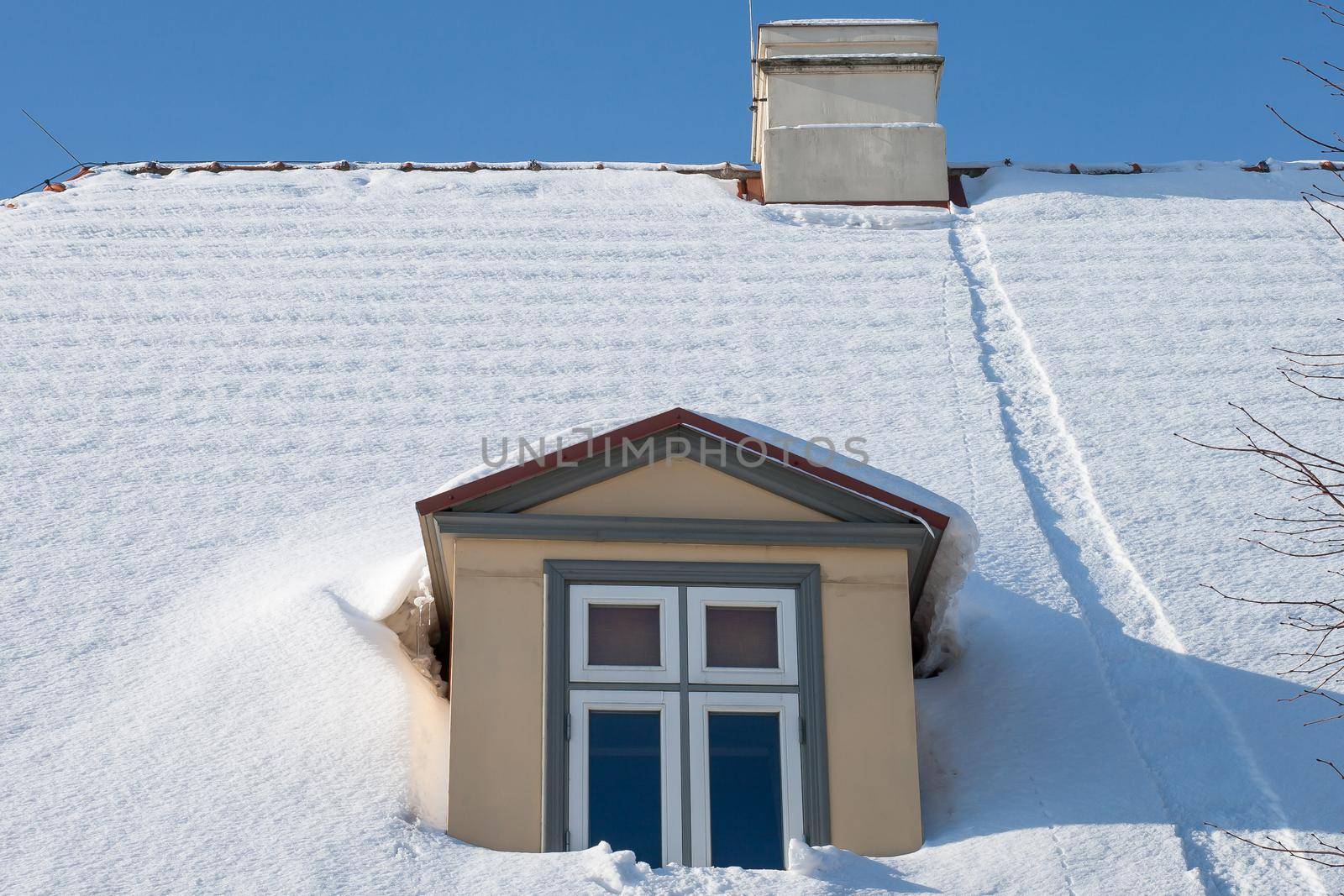 snow-covered house roof and window on it
