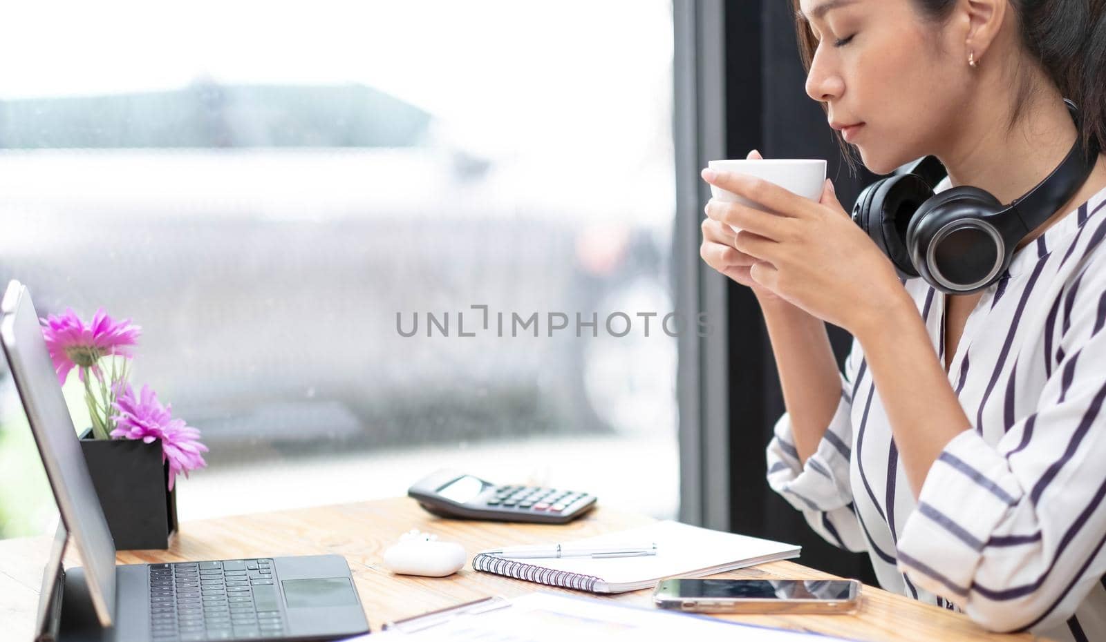 Image of a young woman through a laptop's web camera while holding a cup of coffee in the kitchen at home. by wichayada