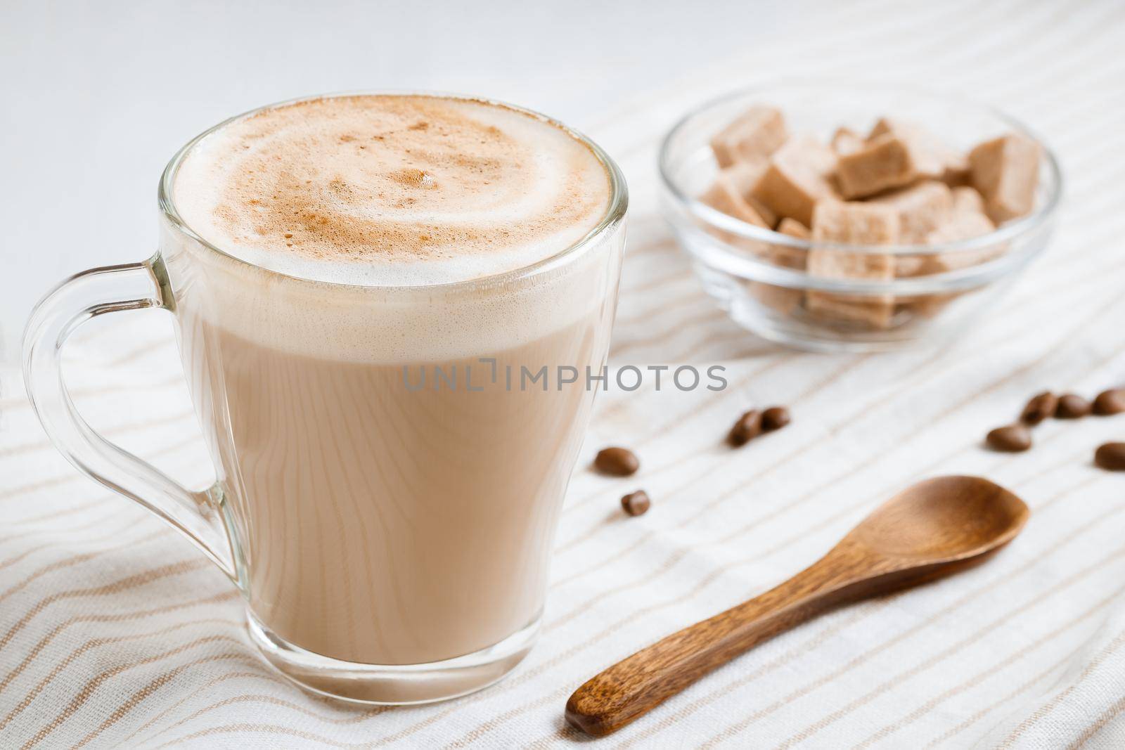 Latte coffee with foam on a light kitchen table.