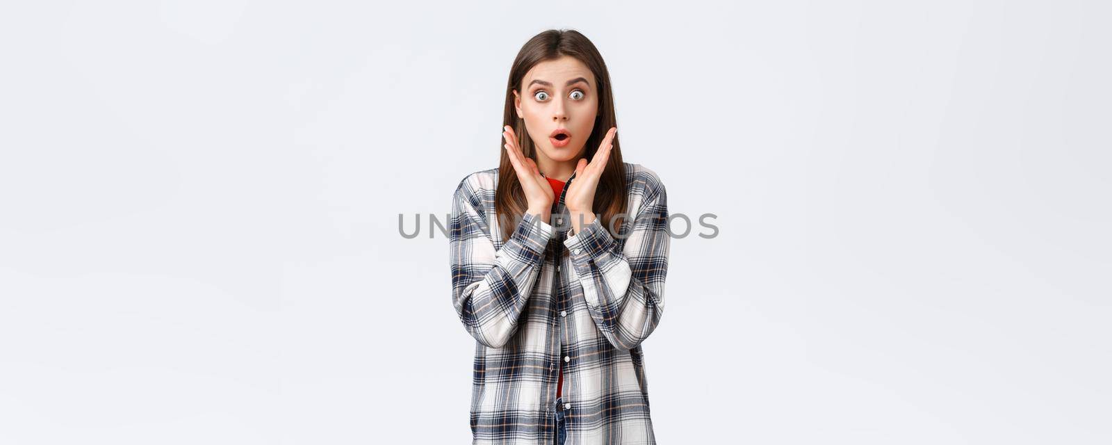 Lifestyle, different emotions, leisure activities concept. Shocked and gasping, startled young caucasian girl in casual outfit, drop jaw, gossiping, say wow and staring amazed camera.