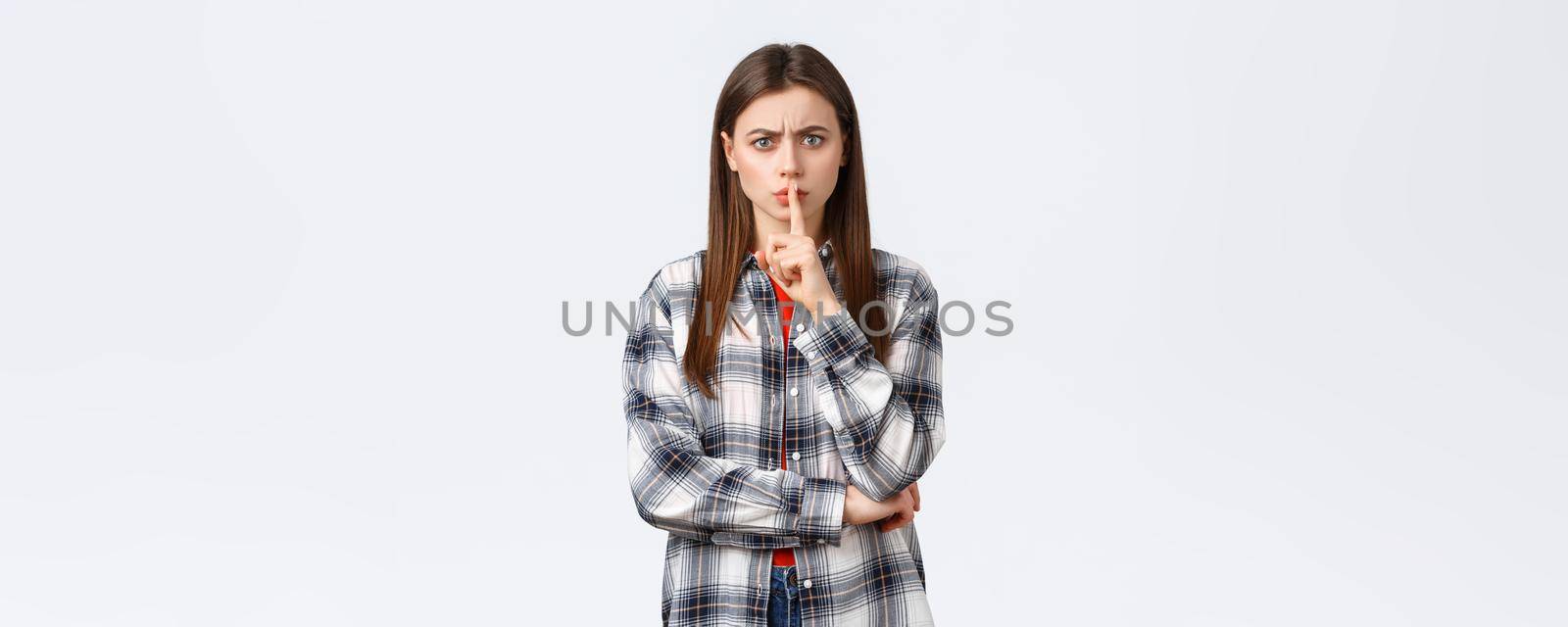 Lifestyle, different emotions, leisure activities concept. Angry serious-looking young woman tell shut up, keep quiet. Girl shushing at you with index finger pressed to lips, frowning disappointed by Benzoix