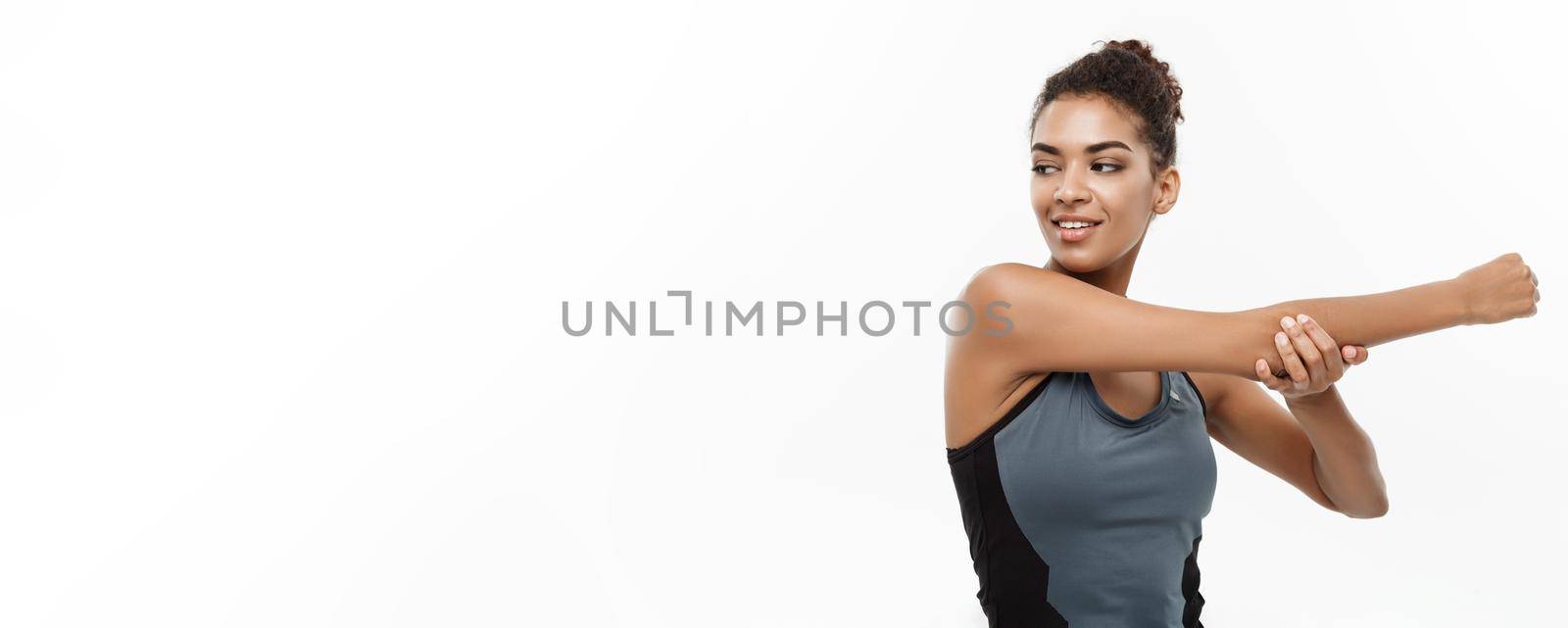 Sport, training, lifestyle and Fitness concept - portrait of beautiful happy African American woman stretching hands. Isolated on white studio background