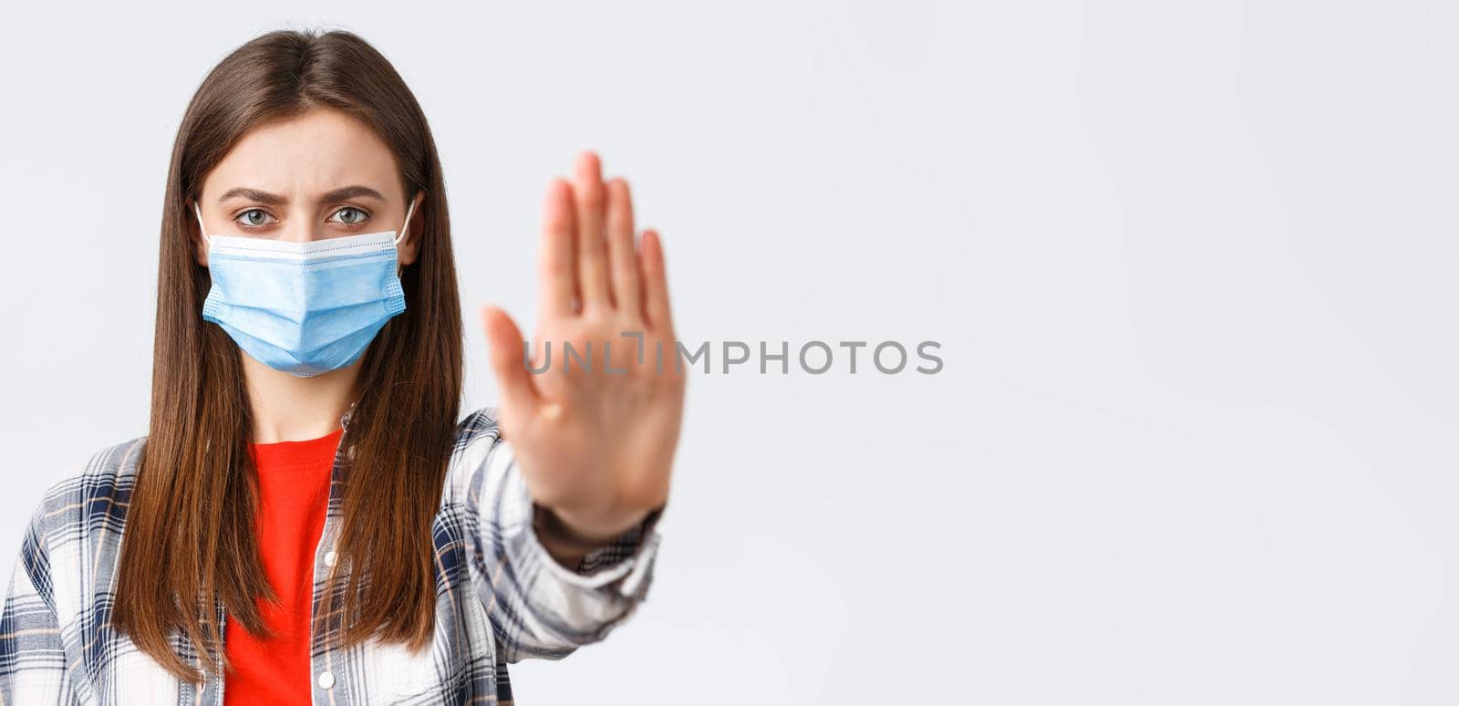Coronavirus outbreak, leisure on quarantine, social distancing and emotions concept. Close-up of serious determined young woman want prevent or stop smth, stretch hand in restriction or warning.