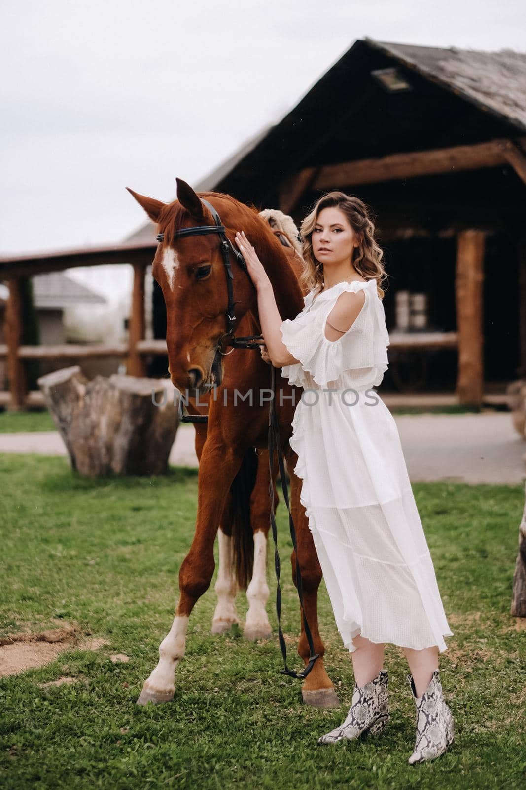 Beautiful girl in a white sundress next to a horse on an old ranch by Lobachad