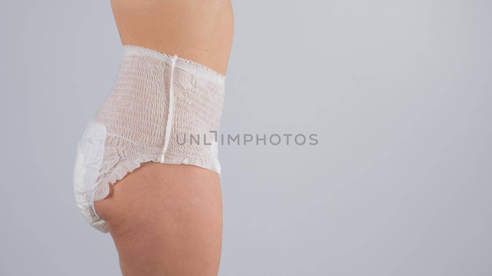 Side view of a Woman in adult diapers on a white background. Incontinence problem